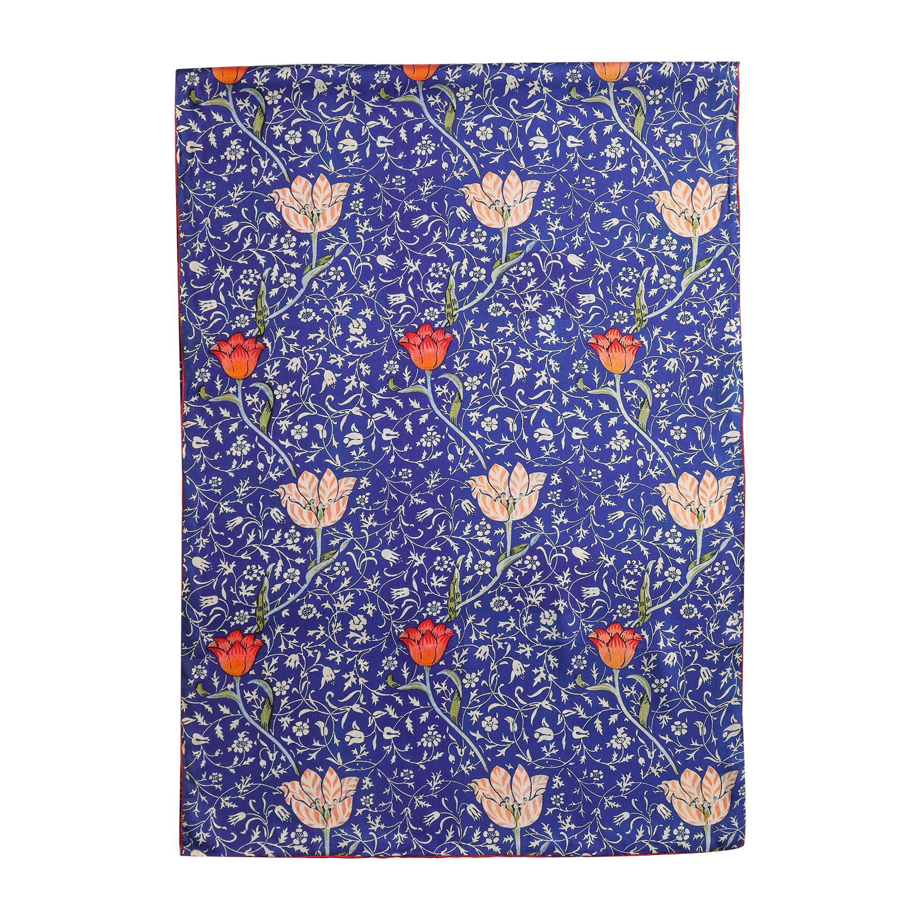 The Floral Blue Silk Scarf Galata is a rectangular silk scarf in blue, featuring a repeating floral pattern with white and red flowers, green leaves, and Art Nouveau-inspired white vine motifs.