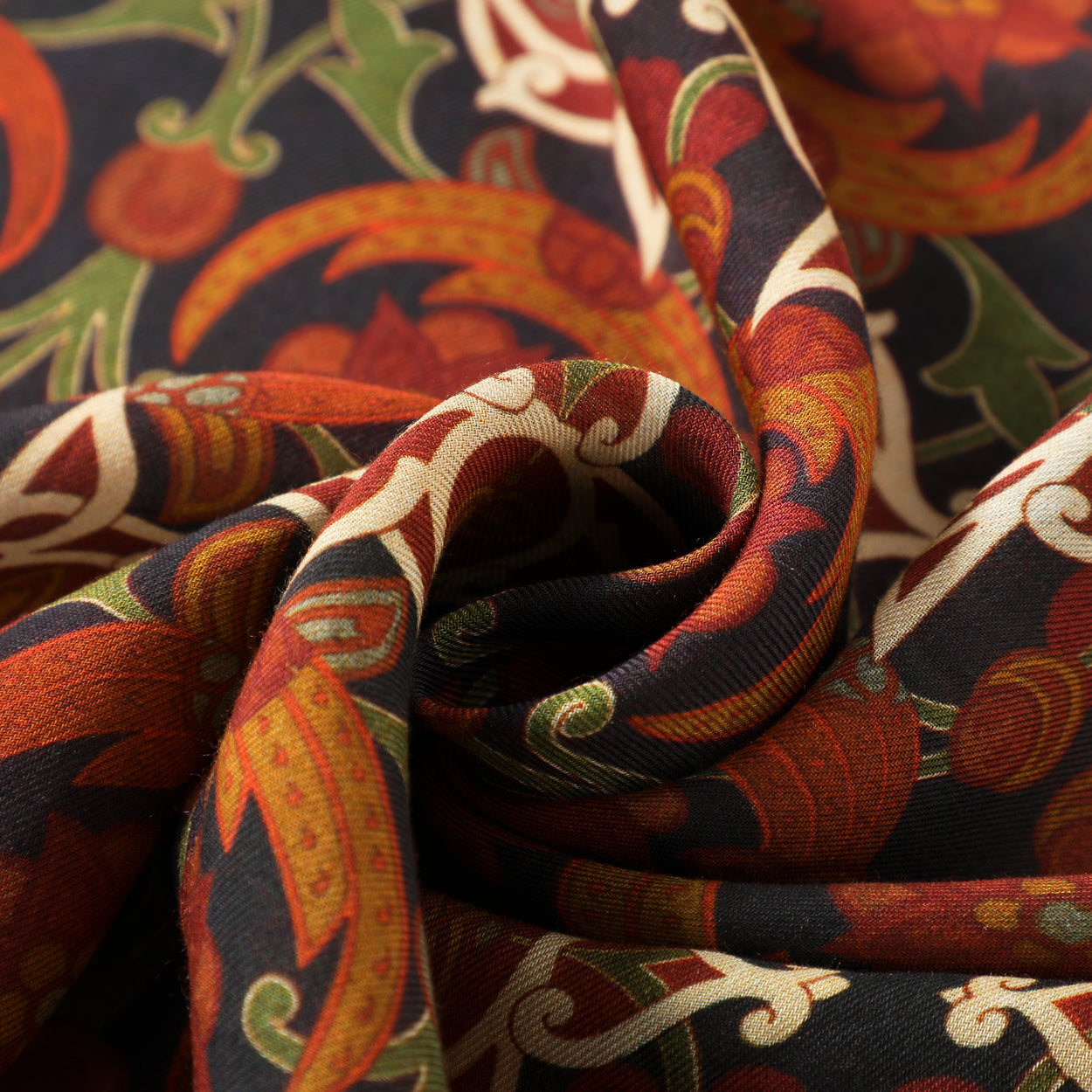 Close-up of the Elegant Womens Scarf with Islamic Art-Inspired Print Samani, showcasing a swirling fold and intricate floral and leaf motifs in warm red, orange, cream, and green tones on a dark background—a versatile accessory.