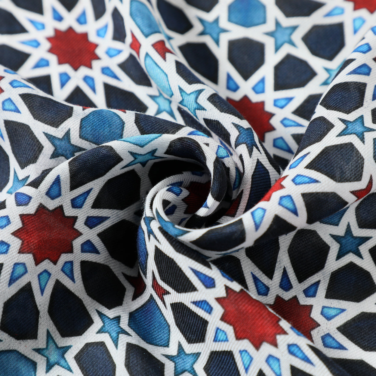 Close-up of the Islamic Art Inspired Scarf in Blue, Red, and Black, featuring lightweight modal fabric with interlocking stars and polygons, gathered in soft folds—a striking accessory rooted in cultural heritage.