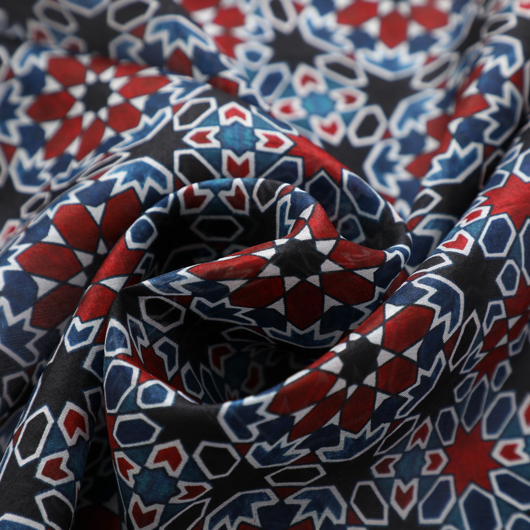 Close-up of the Red & Blue Silk Scarf Islamic Tiles Mashrabia V2, featuring a geometric Islamic tile pattern. The soft, crumpled silk highlights intricate star shapes and symmetry, evoking luxury and elegance.