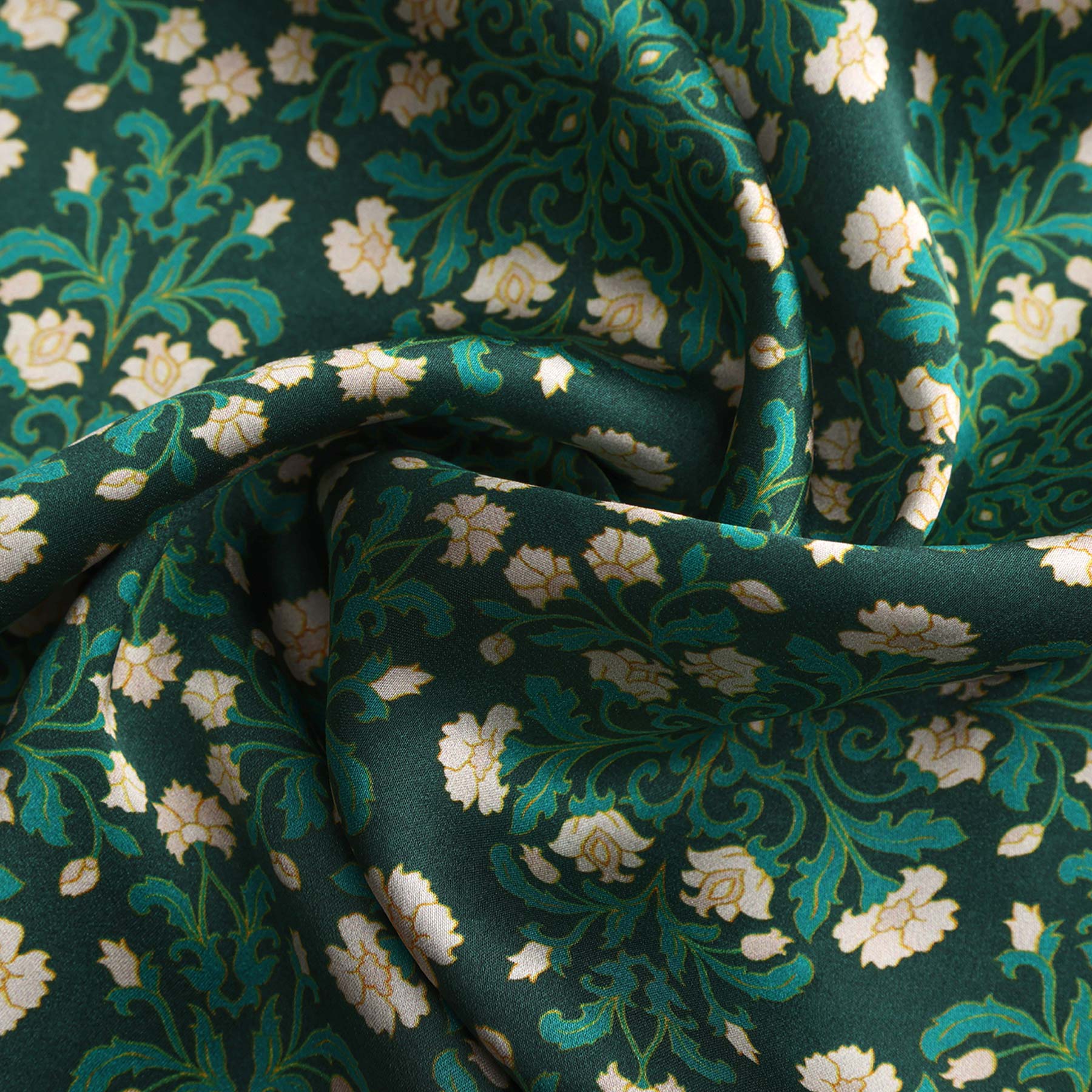 A rectangular green silk scarf featuring delicate white floral patterns and elegant detailing, reminiscent of an art nouveau accessory.