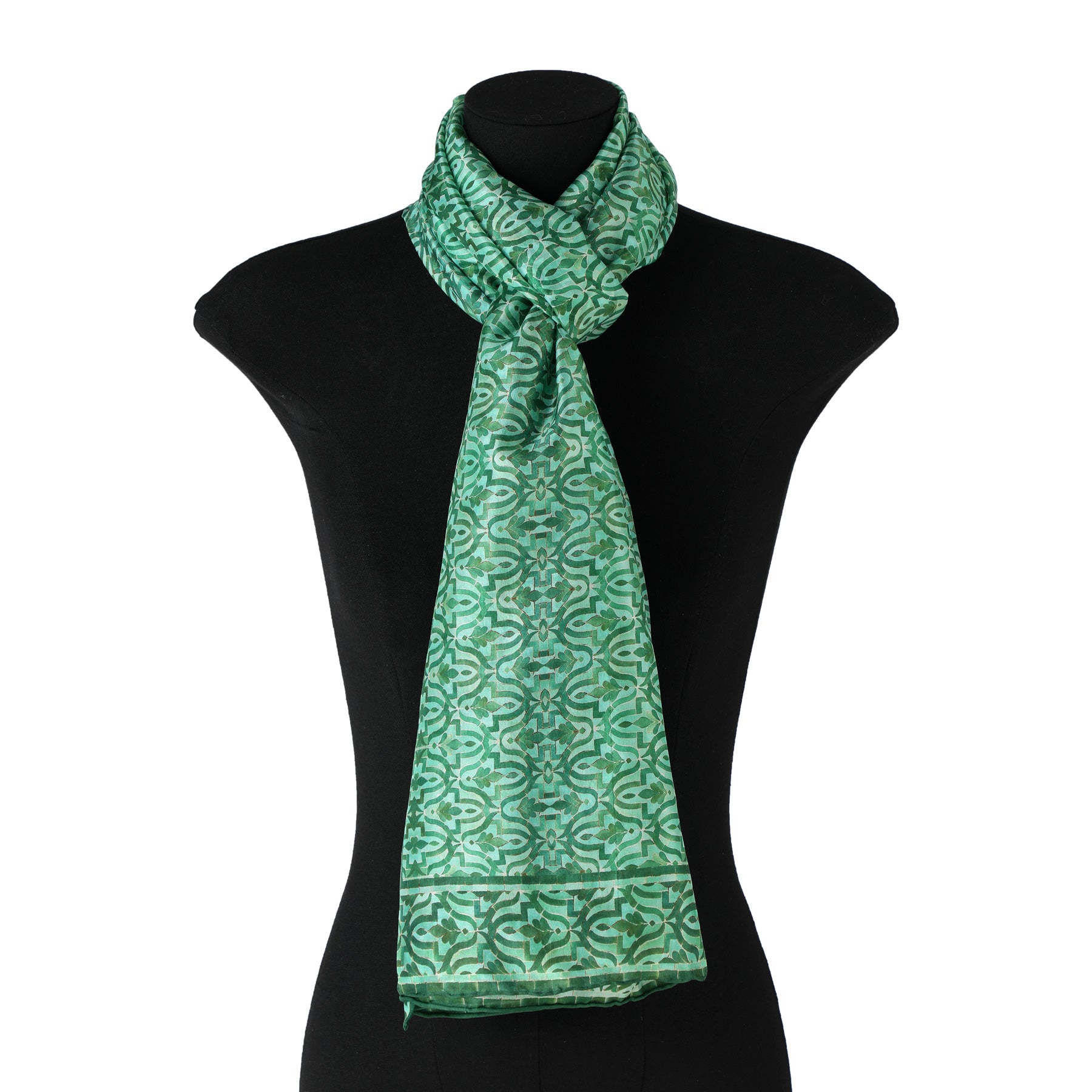 The Green Silk Scarf Islamic Tiles features intricate North Moroccan tile-inspired designs, elegantly draped on a black dress form mannequin with one end hanging longer than the other.