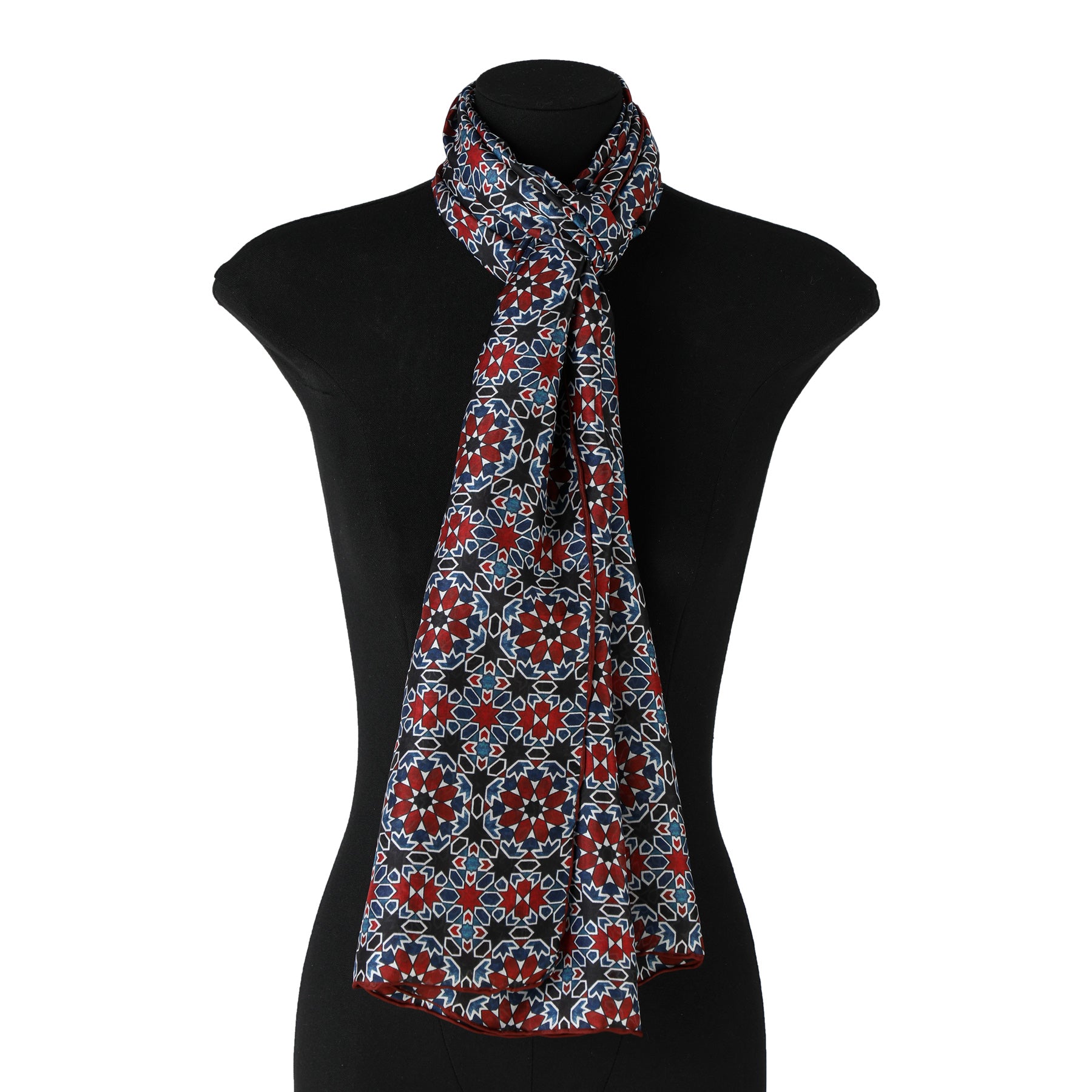 A black mannequin displays the Red & Blue Silk Scarf Islamic Tiles Mashrabia V2, featuring a floral geometric pattern, elegantly tied at the neck against a plain white background to highlight its luxury.