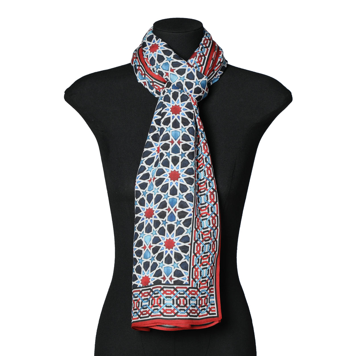 A black mannequin shows the Islamic Art Inspired Scarf in Blue, Red, and Black, made from lightweight modal fabric with geometric patterns and a contrasting border, neatly tied around the neck.