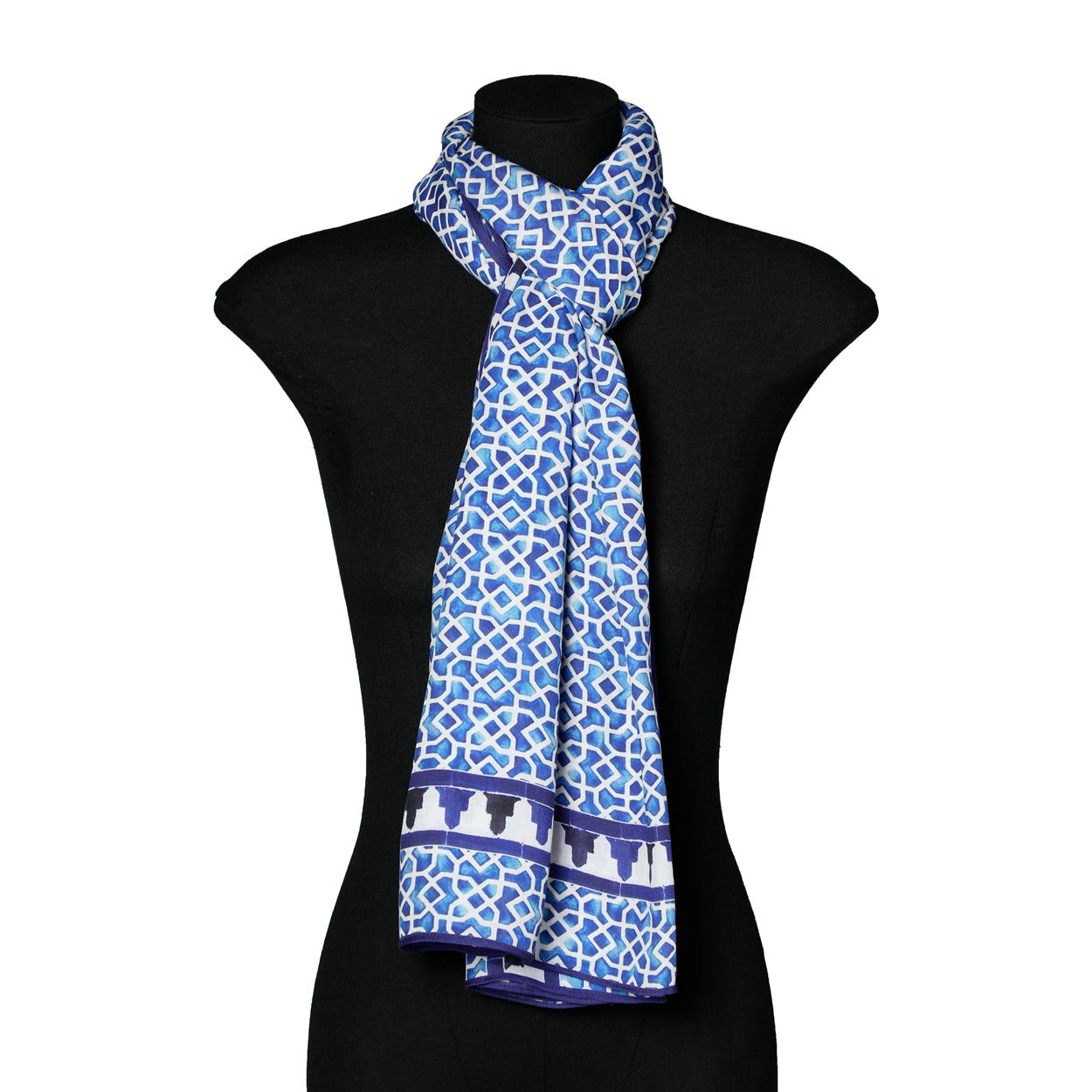 The Blue and White Scarf Islamic Art - Aziza Iqbal - Alcazaba Azul features geometric Islamic patterns and a darker blue bordered motif, elegantly draped on a black mannequin, crafted from premium modal fabric.