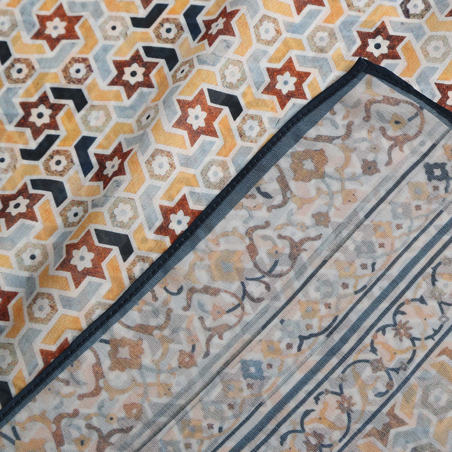 Pañuelo Manzar – estampado de mosaico andalusí en arena y azul marino, detalle 4
