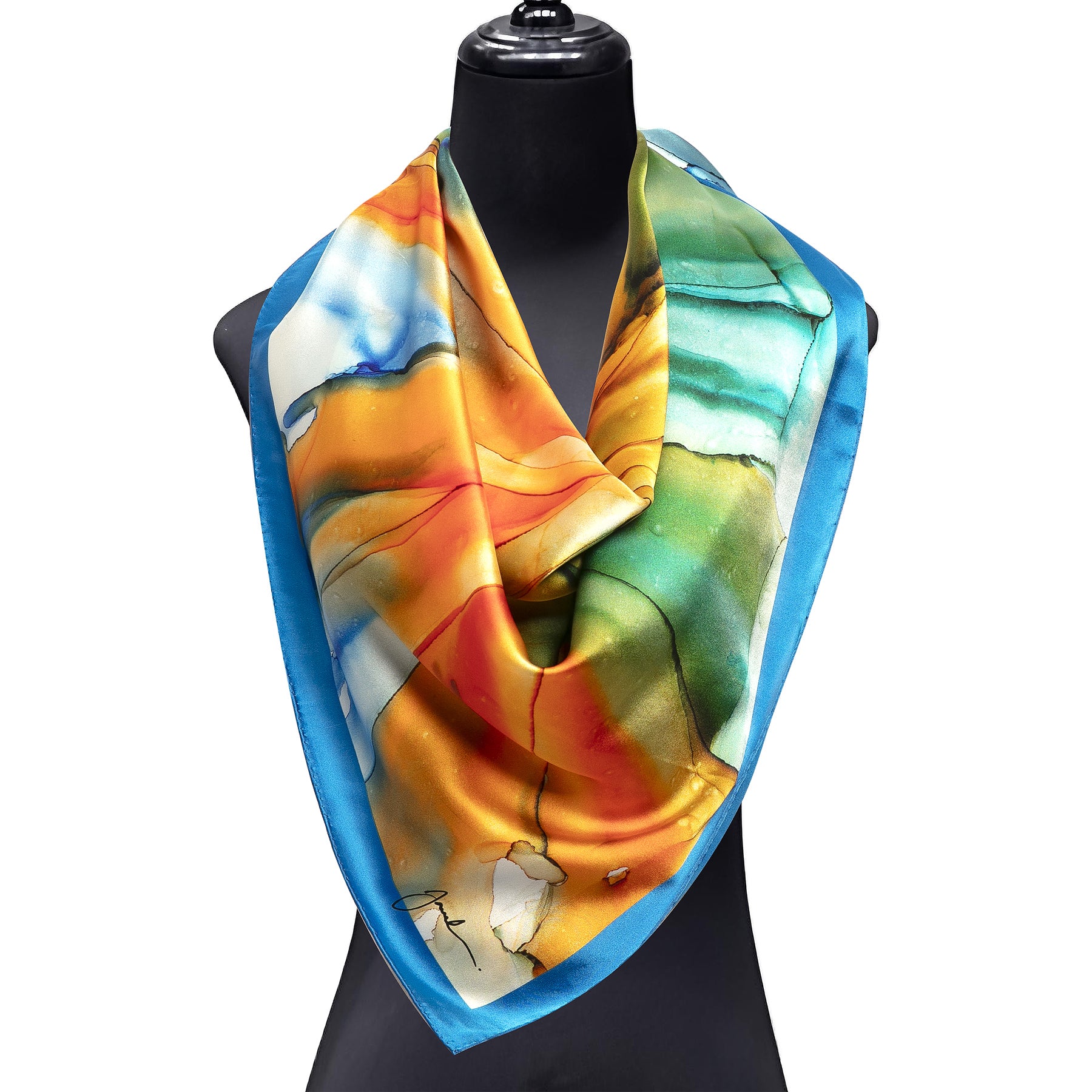 The Hamzah Blue and Orange Silk Scarf Square features a fluid art print in blue, green, yellow, and orange tones with a blue border. Draped on a black mannequin bust, its satin finish exudes sophistication and vibrant style.