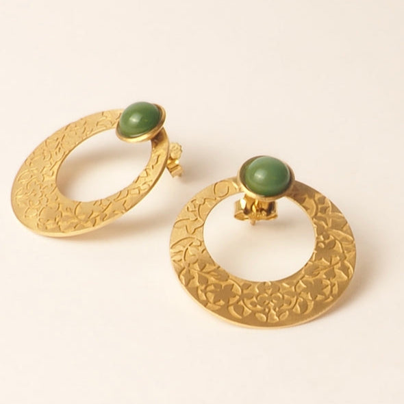 These luxurious Gold Earrings with Green Glass Stone, embossed with Alhambra Palace details, feature a textured design and a flat base. By Platónica, they are an elegant addition to any ensemble.