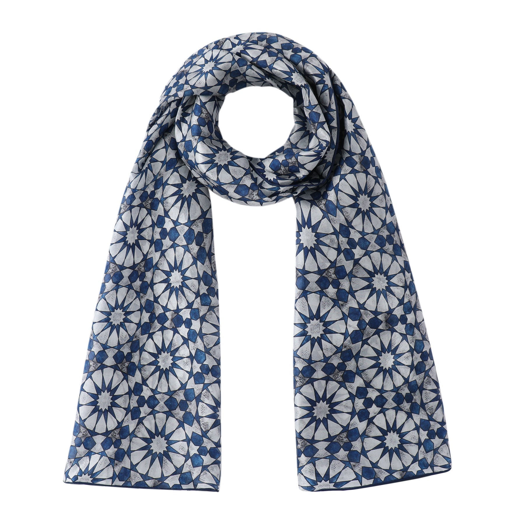 The Hamzah Islamic Tessellation Silk Scarf Muqarnas V2, in blue and white Habotai silk, features a striking symmetrical geometric pattern with star-like designs. It drapes elegantly in a loose loop with even ends.