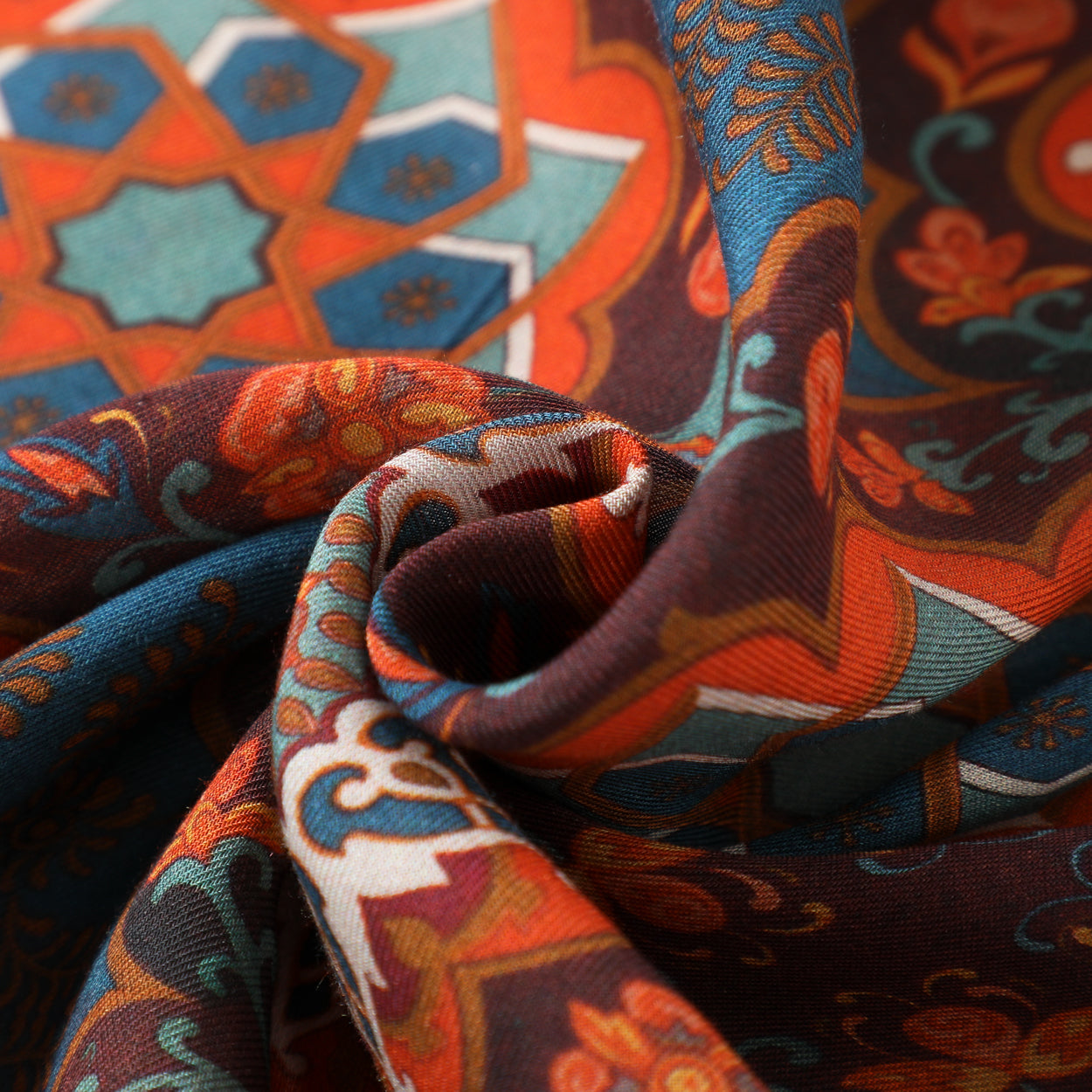 A close-up of the Bahar Islamic Art Scarf in 100% modal, featuring a red and blue mandala design with intricate floral and geometric patterns, softly twisted at the center.