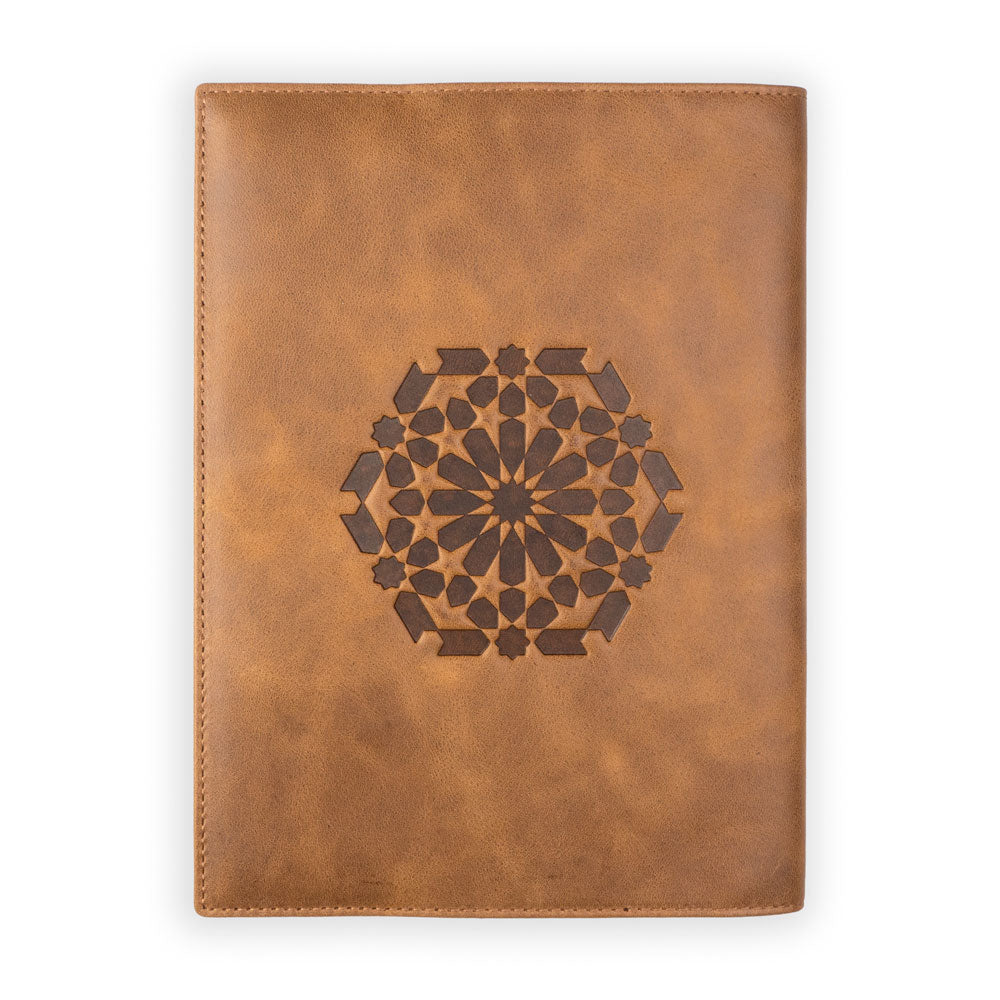 The Munira Leather Leather Notebook Cover Zellige Brown, handmade in Spain, features a geometric star mandala engraved on the front and is displayed against a plain white background.