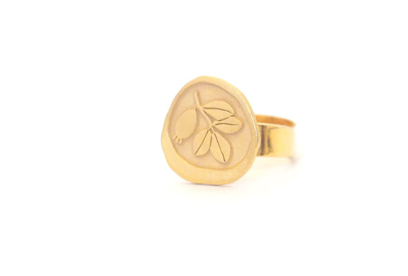 The Gold Plated Ring with Floral Motif Arrayan by Platónica features a round, flat face engraved with a branched leaf design. Crafted by skilled handmade artisans, it boasts a simple band and minimalistic aesthetics set on a plain white backdrop.