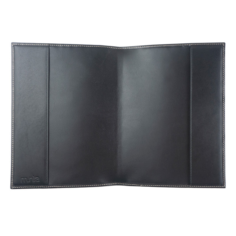 A refillable dark brown Na´layn leather journal cover by Munira Leather, with white edge stitching, lies open and flat. Inside, subtle panel divisions appear and the Munira Leather brand is embossed in the bottom left corner.