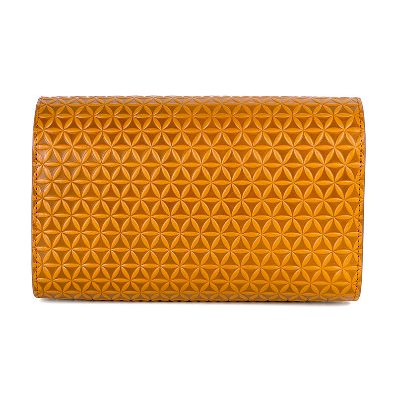 Close up of leather clutch bag with flower of life pattern embossed