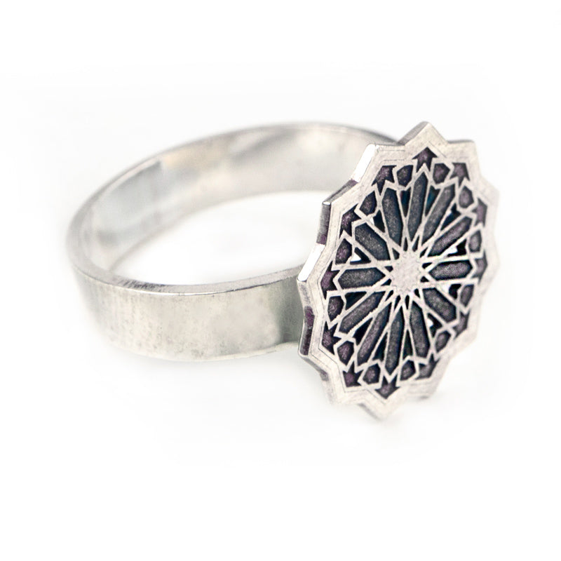 The Platónica Silver Ring Estrella, expertly handmade in Granada, showcases an intricate geometric starburst design on its round sterling silver face against a plain white background.