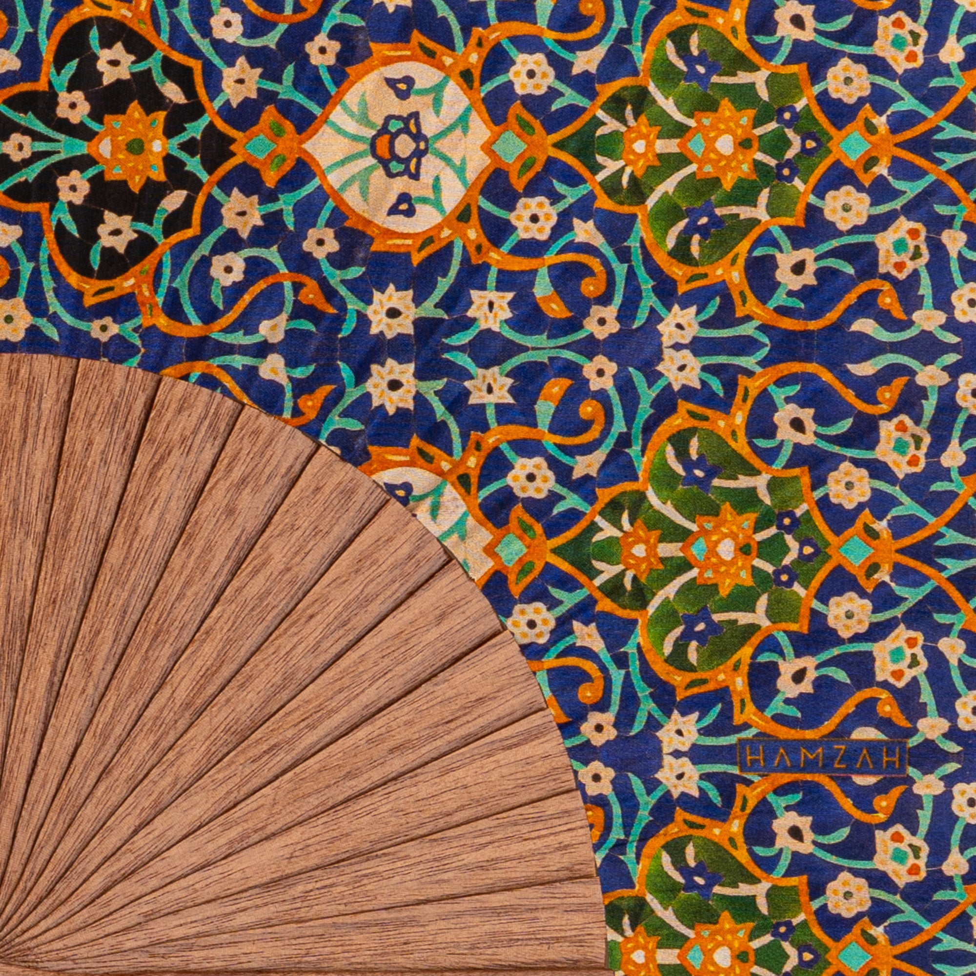 Close-up of the Andalusian Mosaic Hand Fan Itr showing the Andalusian mosaic geometric print in blue and orange in detail.