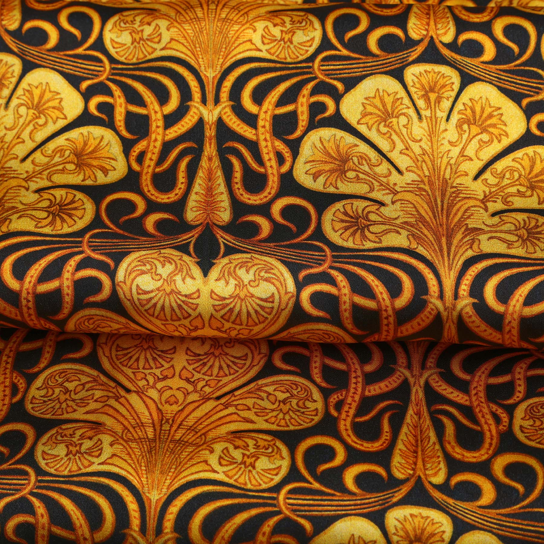 The Black Silk Scarf with Ornate Gold Pattern Reims showcases a rectangular design with intricate gold motifs on black silk, embodying art nouveau luxury—an elegant accessory with dark edges.