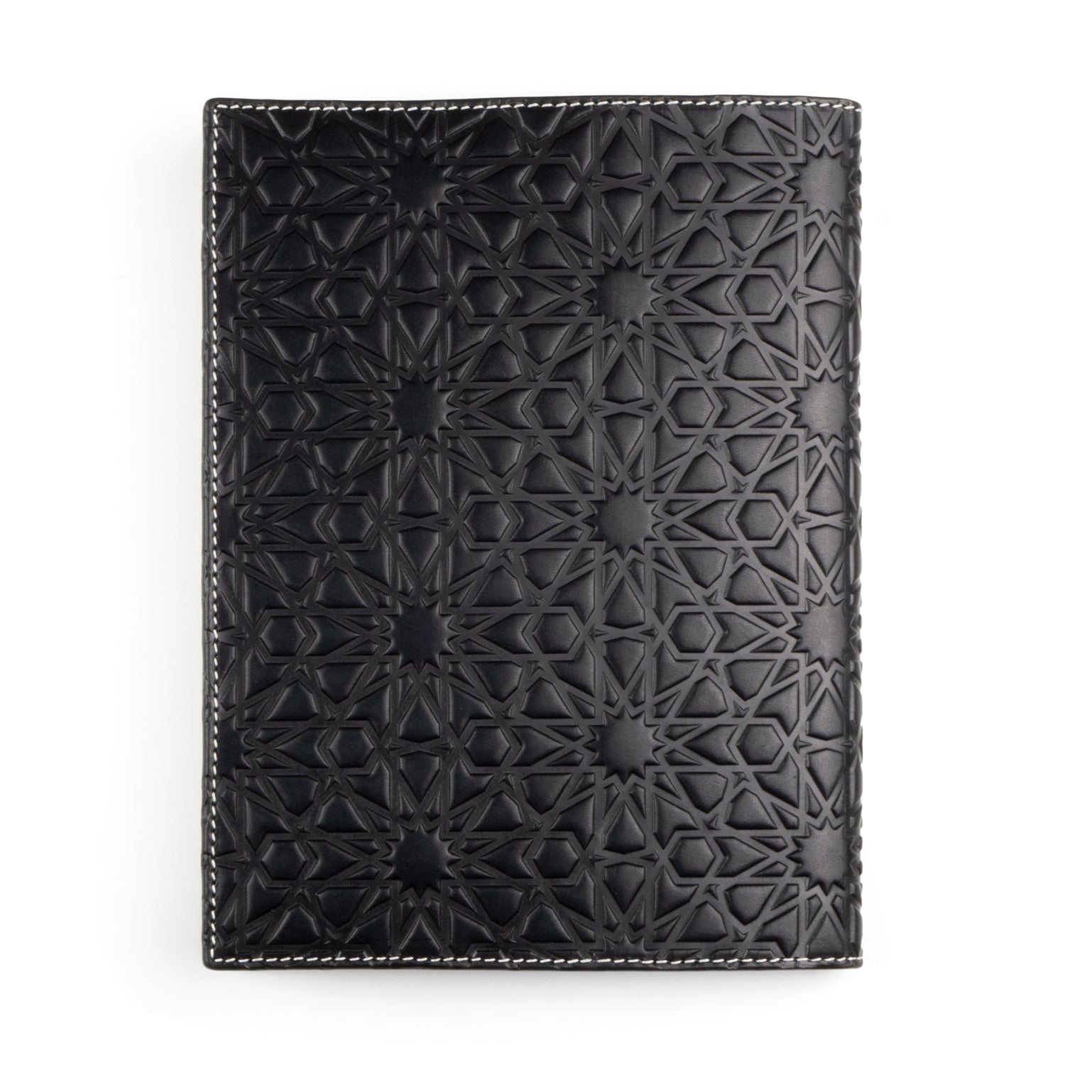 A black leather cover, intricately embossed with a geometric pattern inspired by Islamic art. The design features interconnected shapes resembling stars and polygons, crafted with precision on cowhide leather, bordered with white stitching.