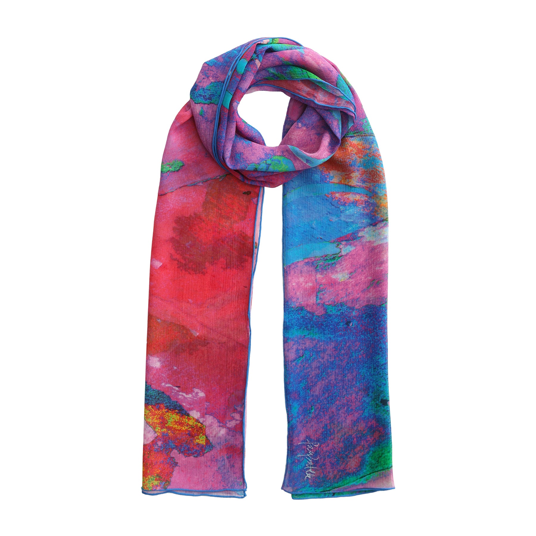 The Multicolor Silk Scarf Océano Fucsia features vibrant abstract patterns in pink, red, blue, green, and yellow—a stunning muslin silk accessory that drapes elegantly as a true wearable artwork.