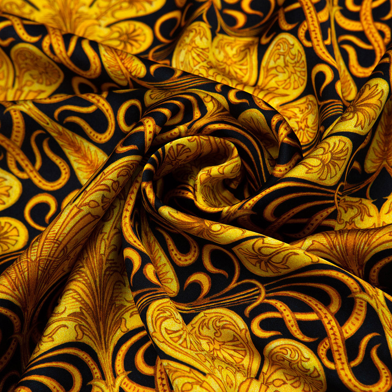 Swirled section of a black scarf revealing elaborate gold scrolls and leaf shapes for a rich, eye-catching design.