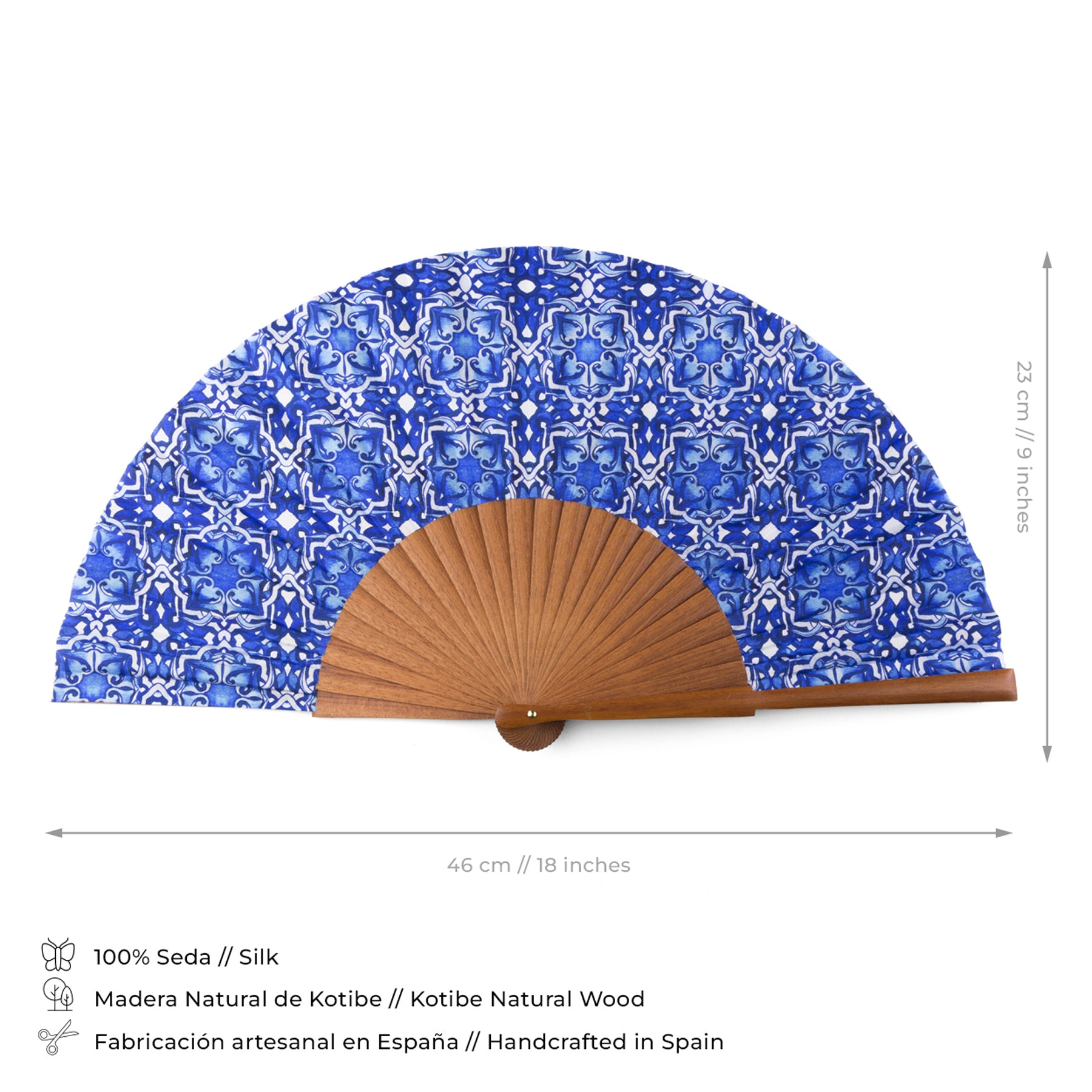 The Blue folding hand fan Farah is handmade in Spain from 100% silk with a blue tile-inspired pattern and natural Kotibe wood. It measures 46 cm wide by 23 cm tall, blending premium materials with elegant design.