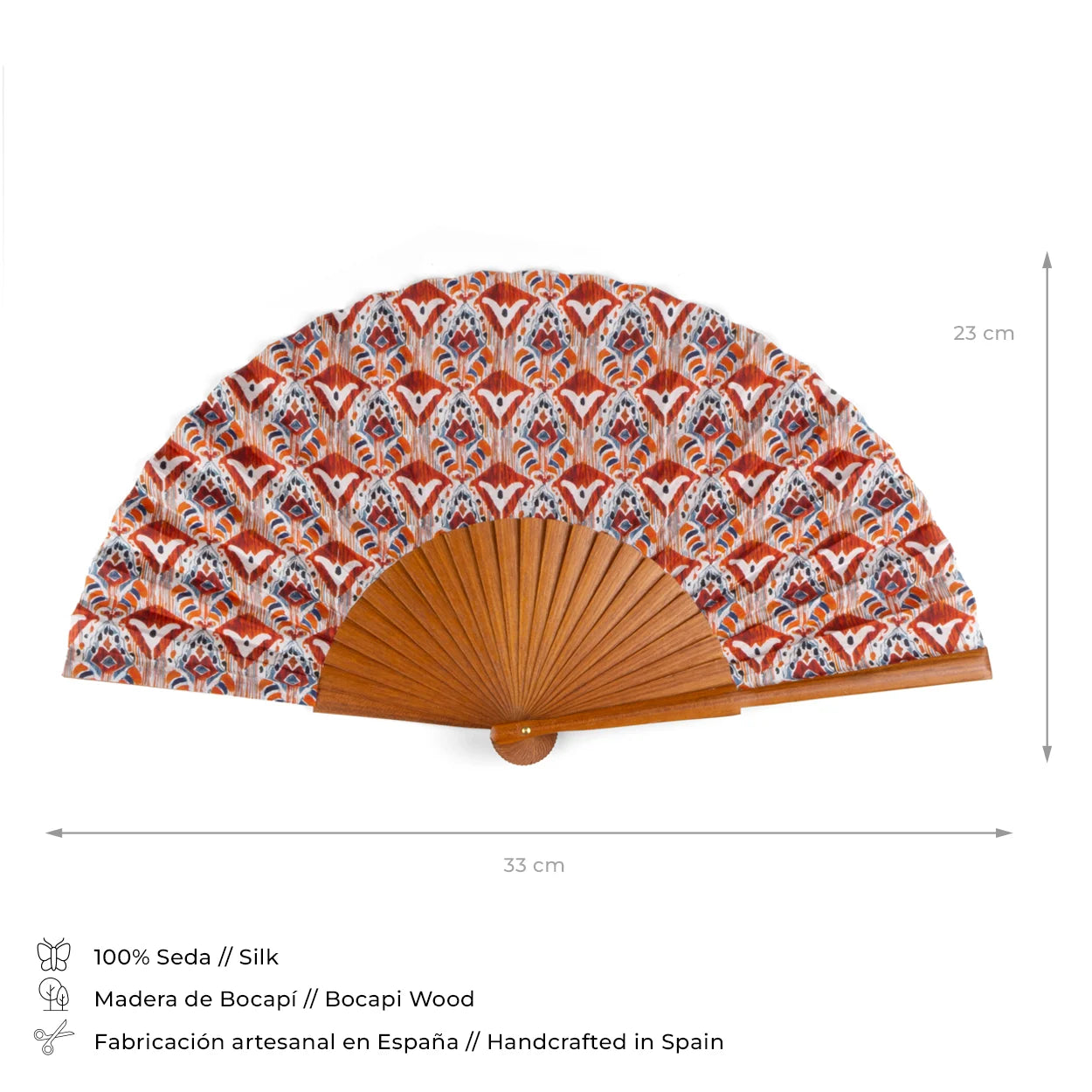 A silk fan with a striking Ikat design in orange, red, and blue, accompanied by a Bocapi wood handle. The fan is 23 cm when opened, crafted by hand in Spain, and presented with detailed product specifications.