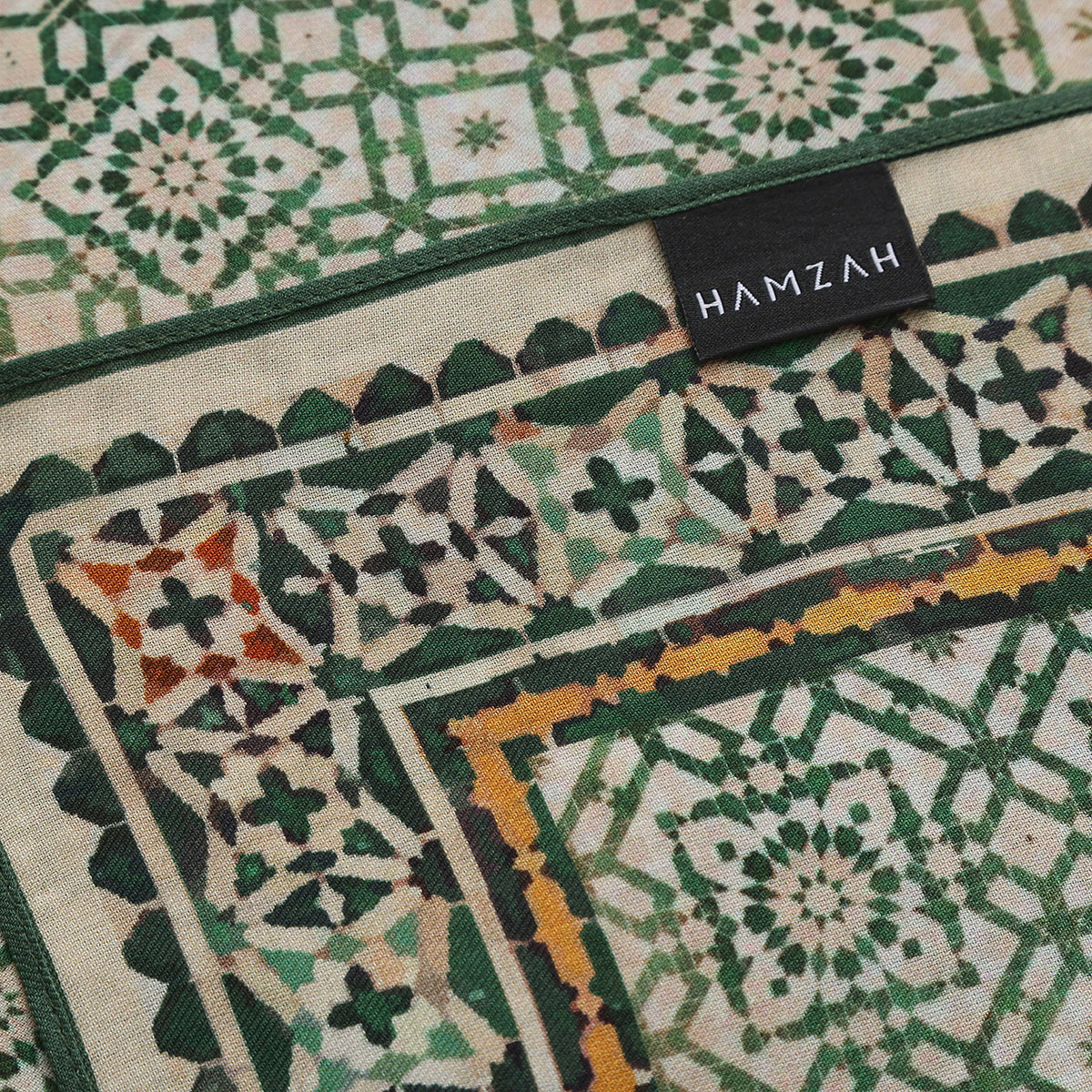 Folded corner of the Green Modal Scarf Alhambra Lattice Azahar, showing the border and the hem