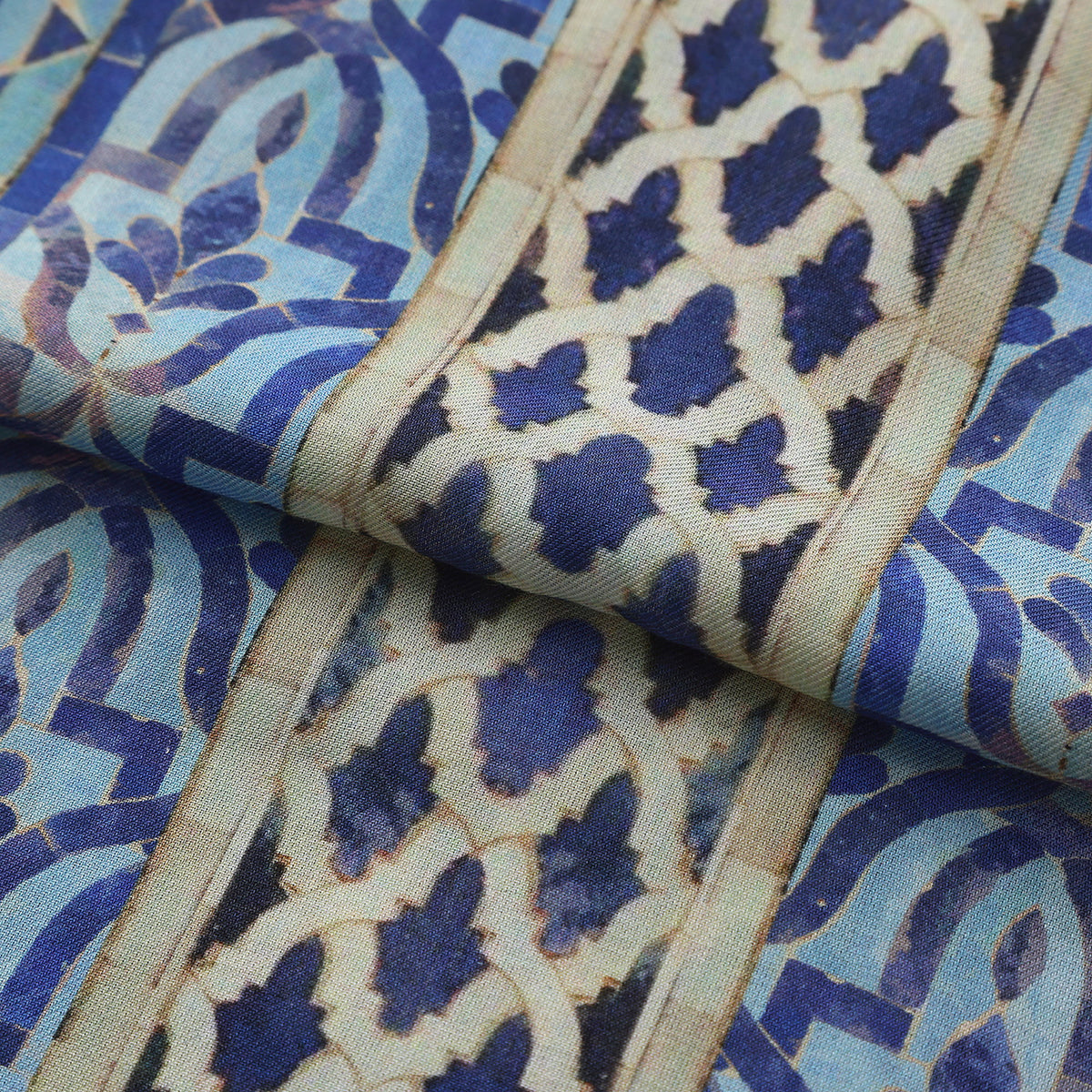 Folded fabric detail of the Blue Modal Scarf Andalusian Tiles Almunia, showing the cobalt star field and the arcade border