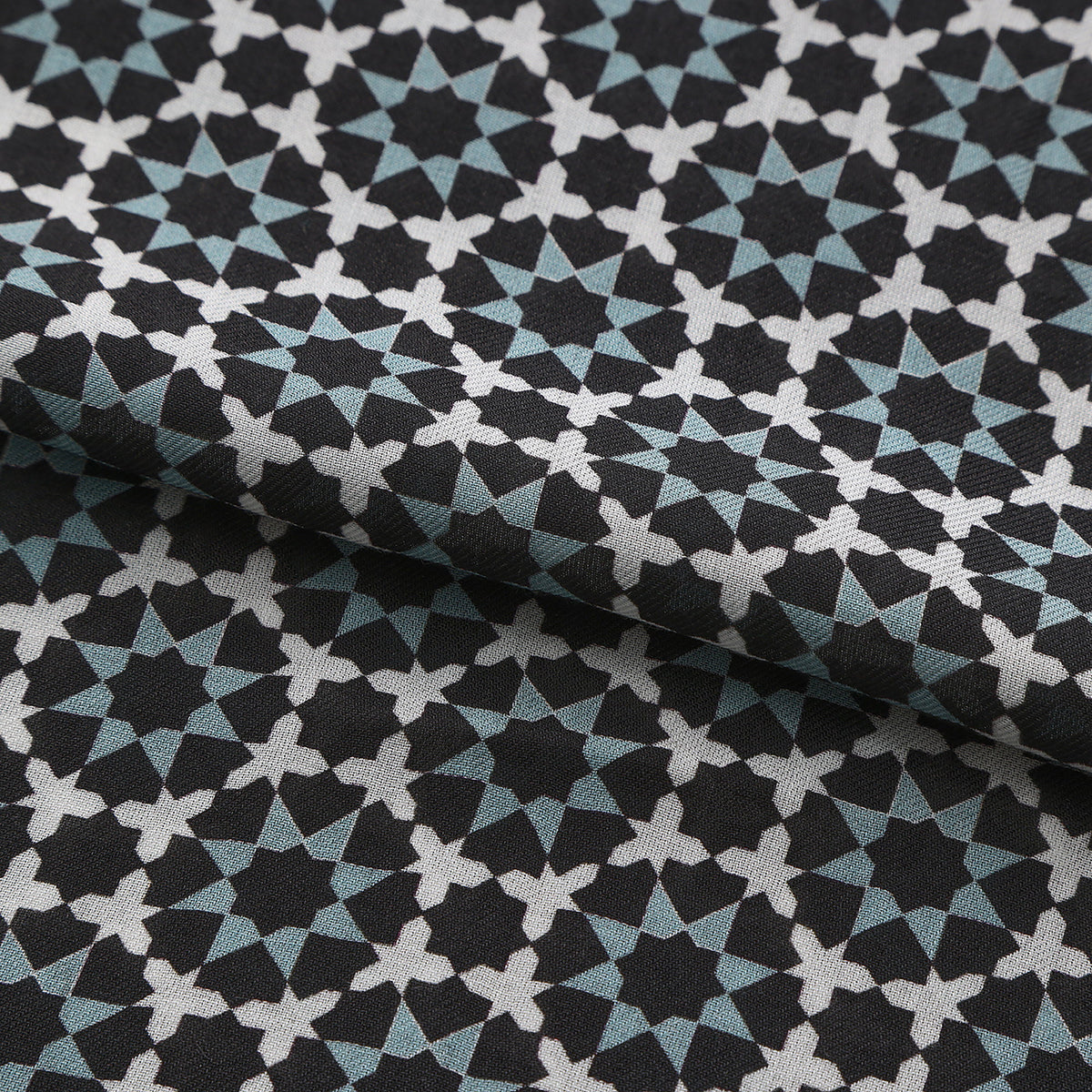 Folded fabric detail of the Black and Grey Modal Scarf Star Lattice Zoraida, showing the black and slate grey star lattice
