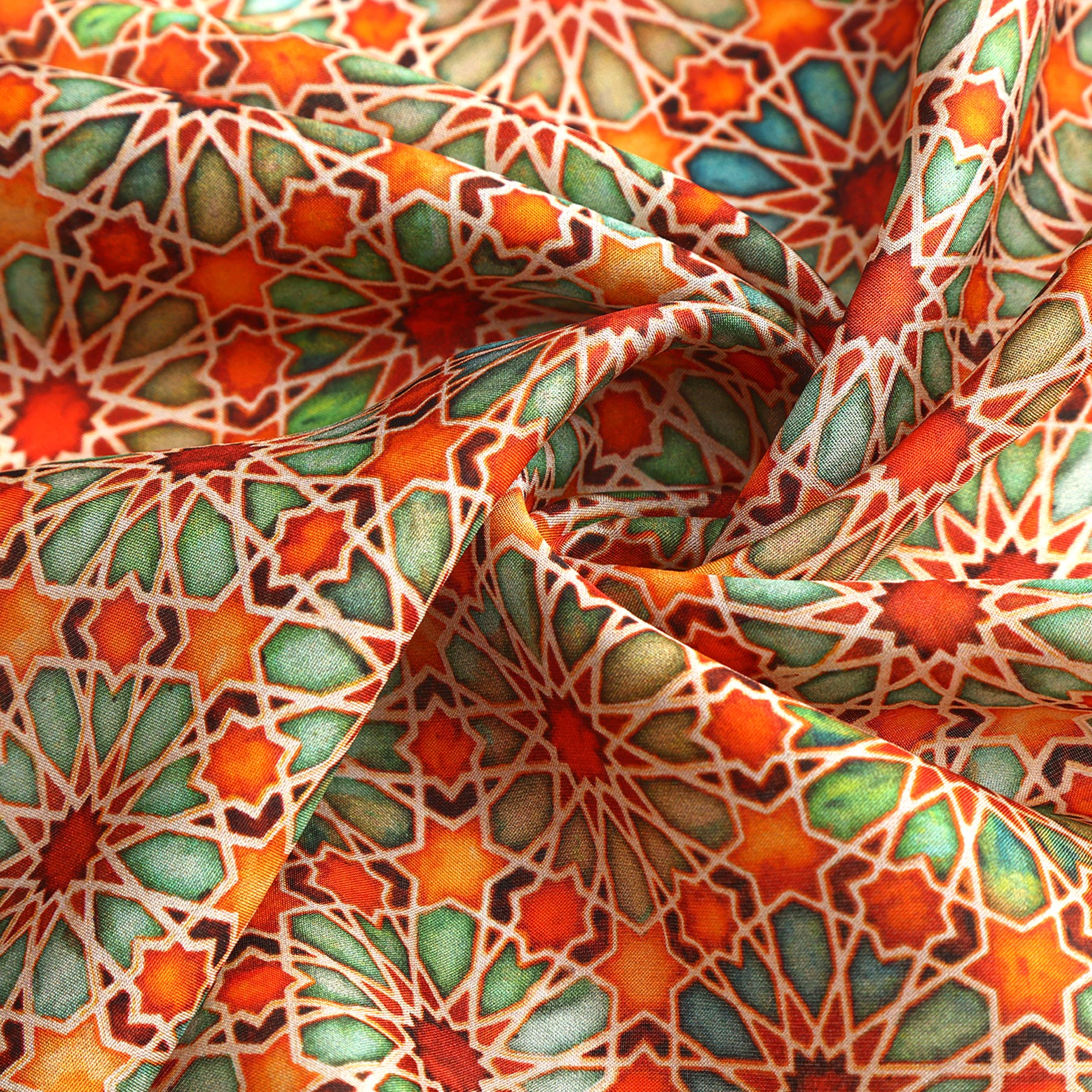 The Orange Square Scarf Zellige features a vibrant geometric pattern with repeating star shapes in red, orange, green, and teal tones, reminiscent of Islamic art. The scarf is elegantly folded and crafted from soft fabric.