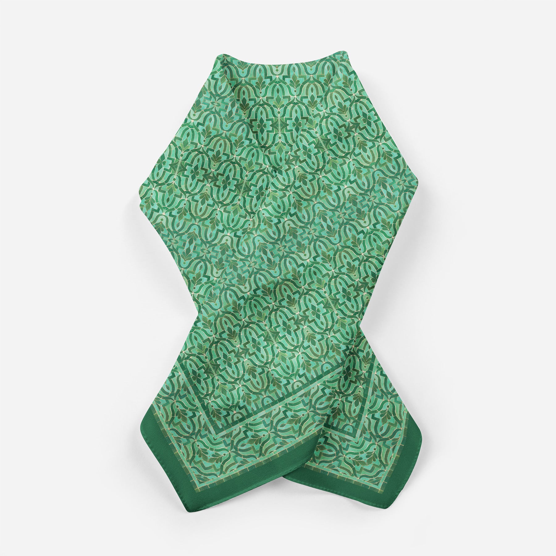 The Green Square Silk Scarf Fihri features an intricate, repeating floral and paisley pattern inspired by Islamic art, with darker green details and a solid green border, displayed flat on a white background.