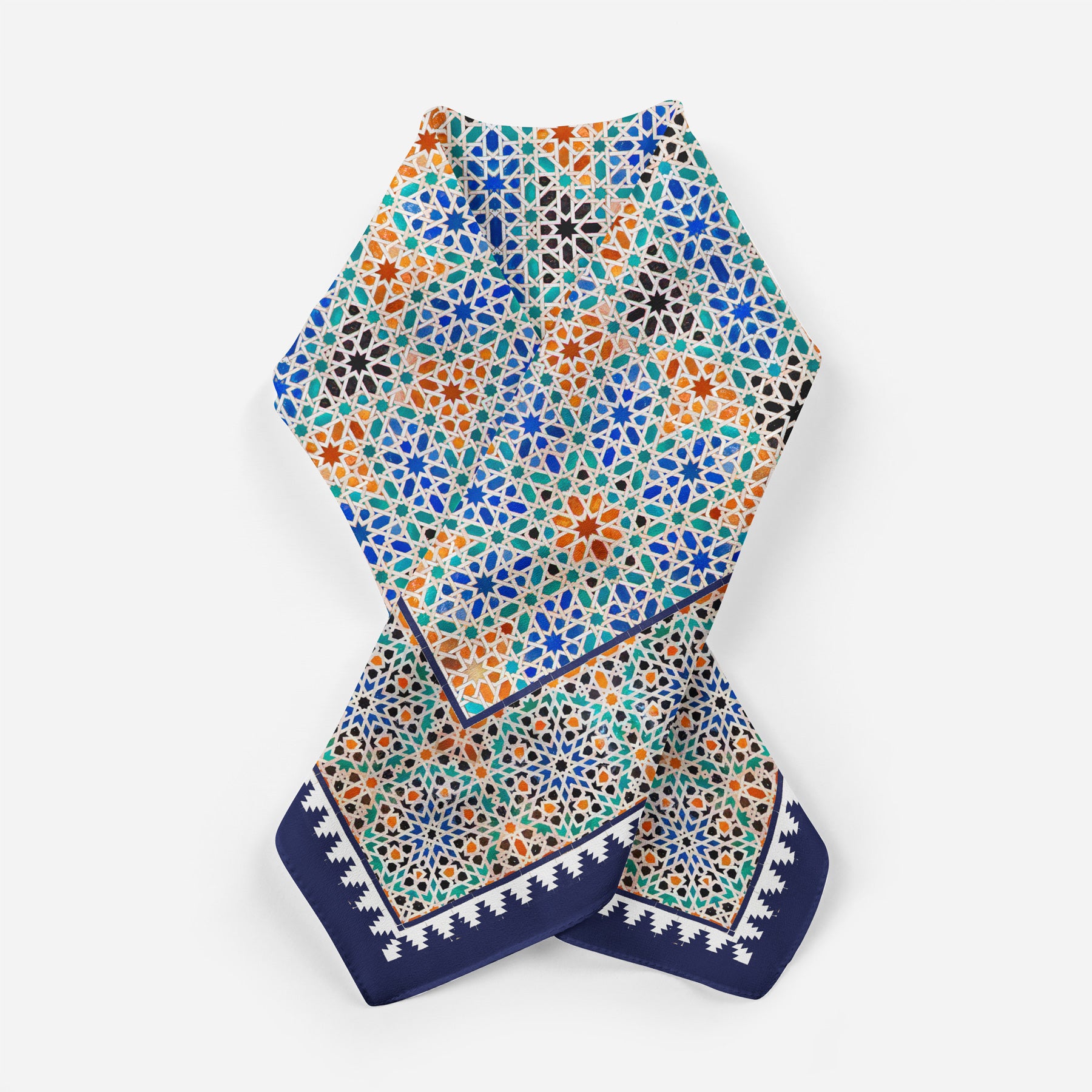 The Square Scarf Blue Madiya is a colorful silk Islamic art scarf with an intricate geometric mosaic pattern in blue, orange, green, and white, plus a navy blue and white border—shown on a white background.