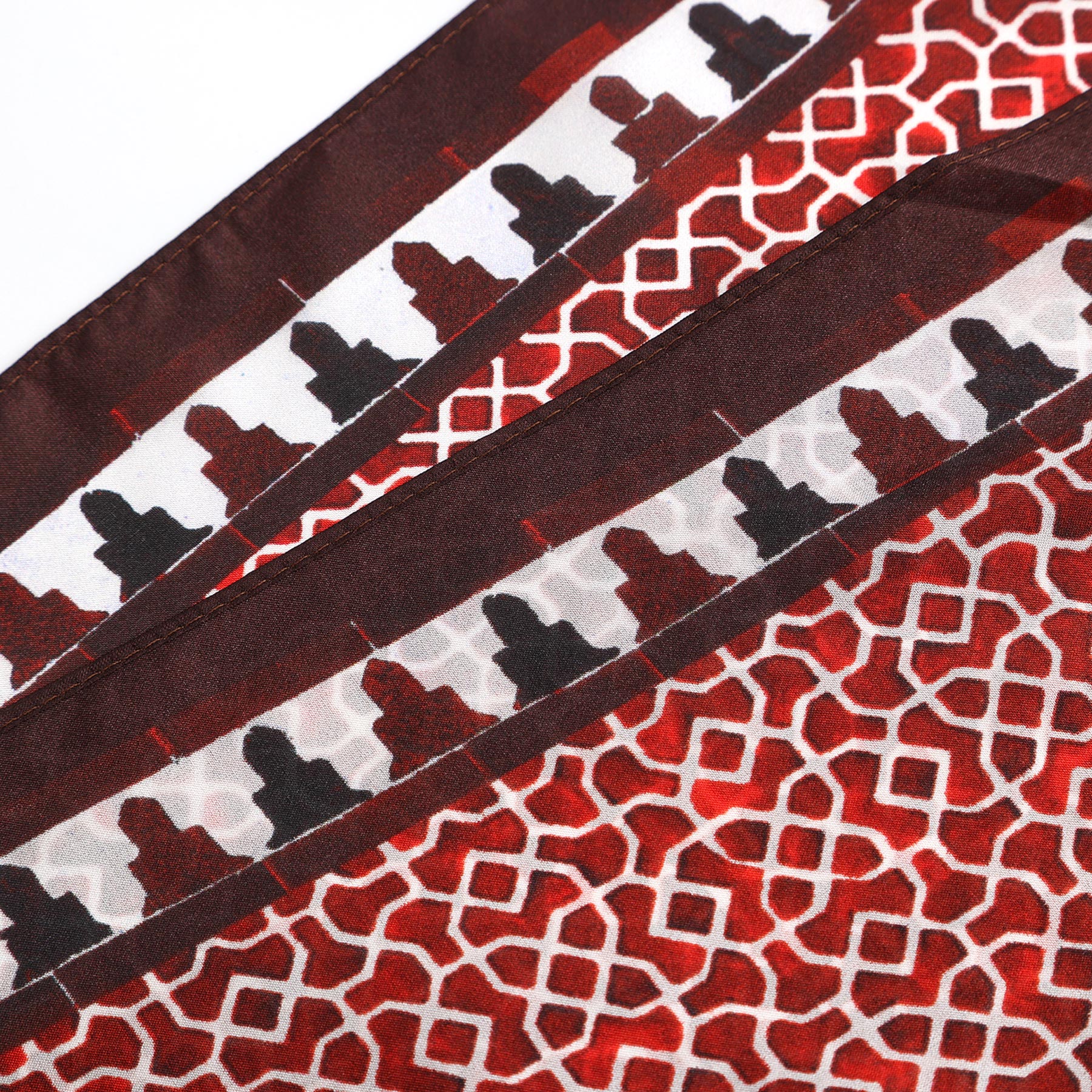 Close-up of the Red Square Scarf 100% Silk, featuring a red base with a white geometric lattice pattern inspired by Alhambra Palace designs and decorative borders echoing Islamic art prints.