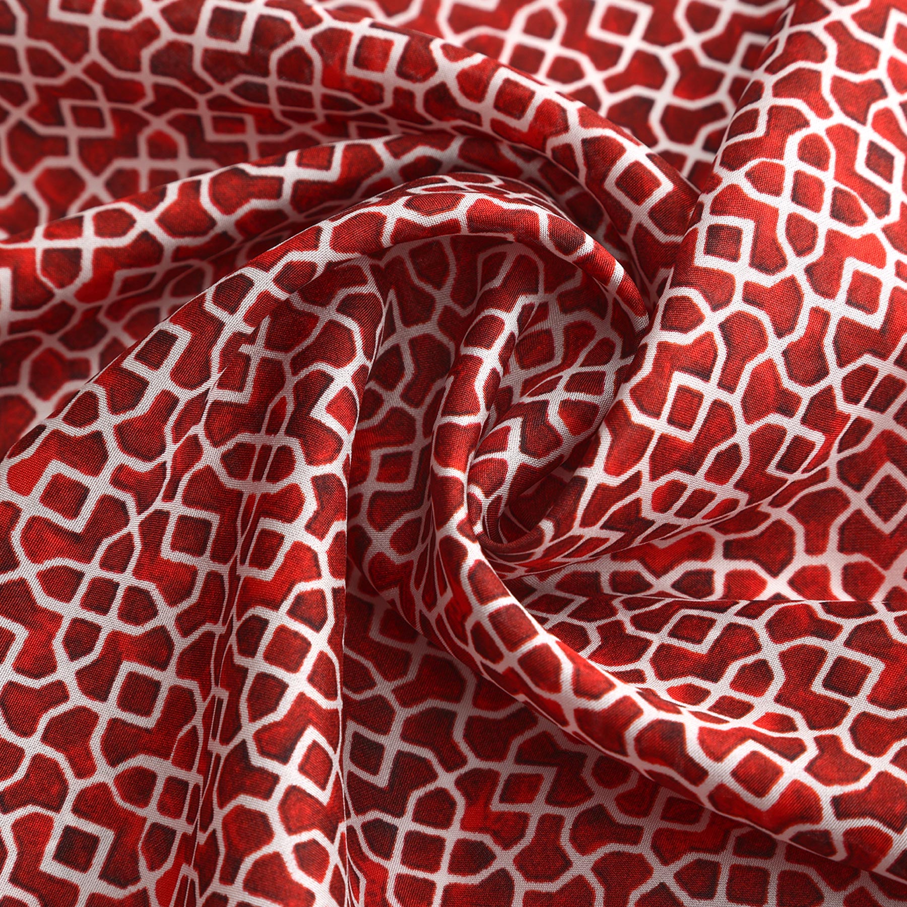 Made from 100% silk, the Red Square Scarf features a red and white geometric pattern, loosely gathered and folded for soft, flowing texture.