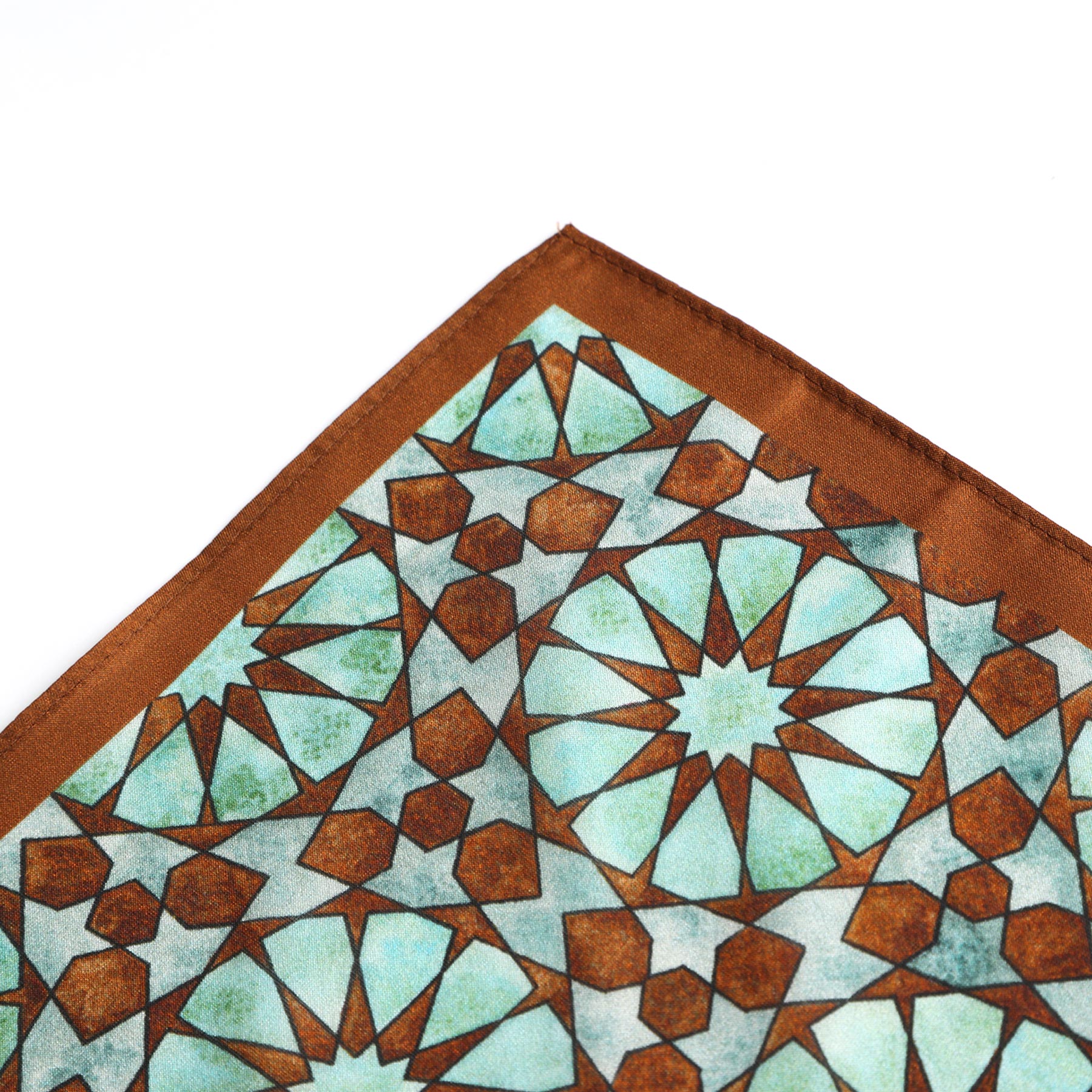 A close-up of the Brown Silk Neckerchief for Women, showing a geometric teal and green pattern inspired by Islamic art, on a white background.