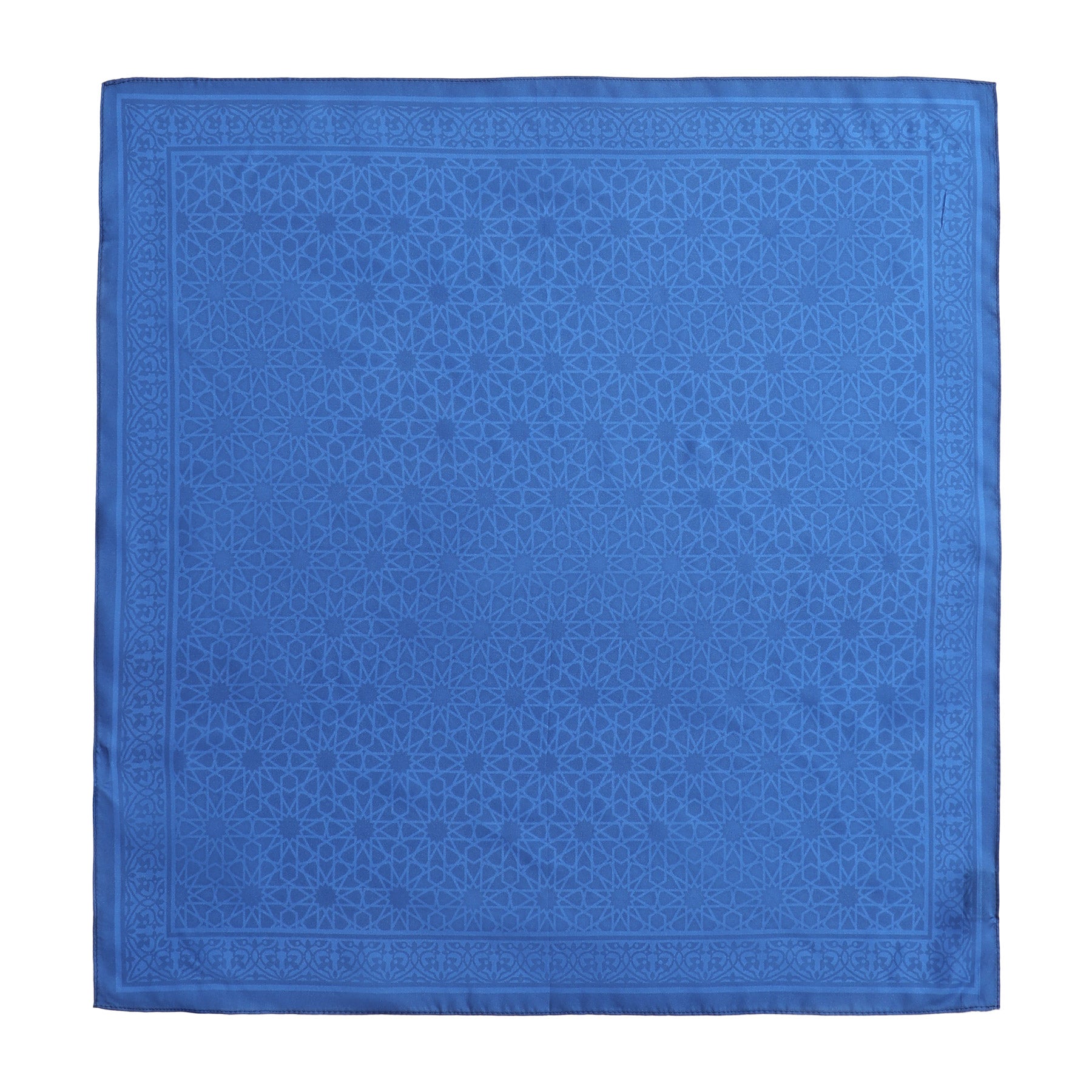 The Blue Square Silk Scarf Dalila v1 features a subtle geometric pattern inspired by Islamic art and a border reminiscent of the Alhambra Palace.