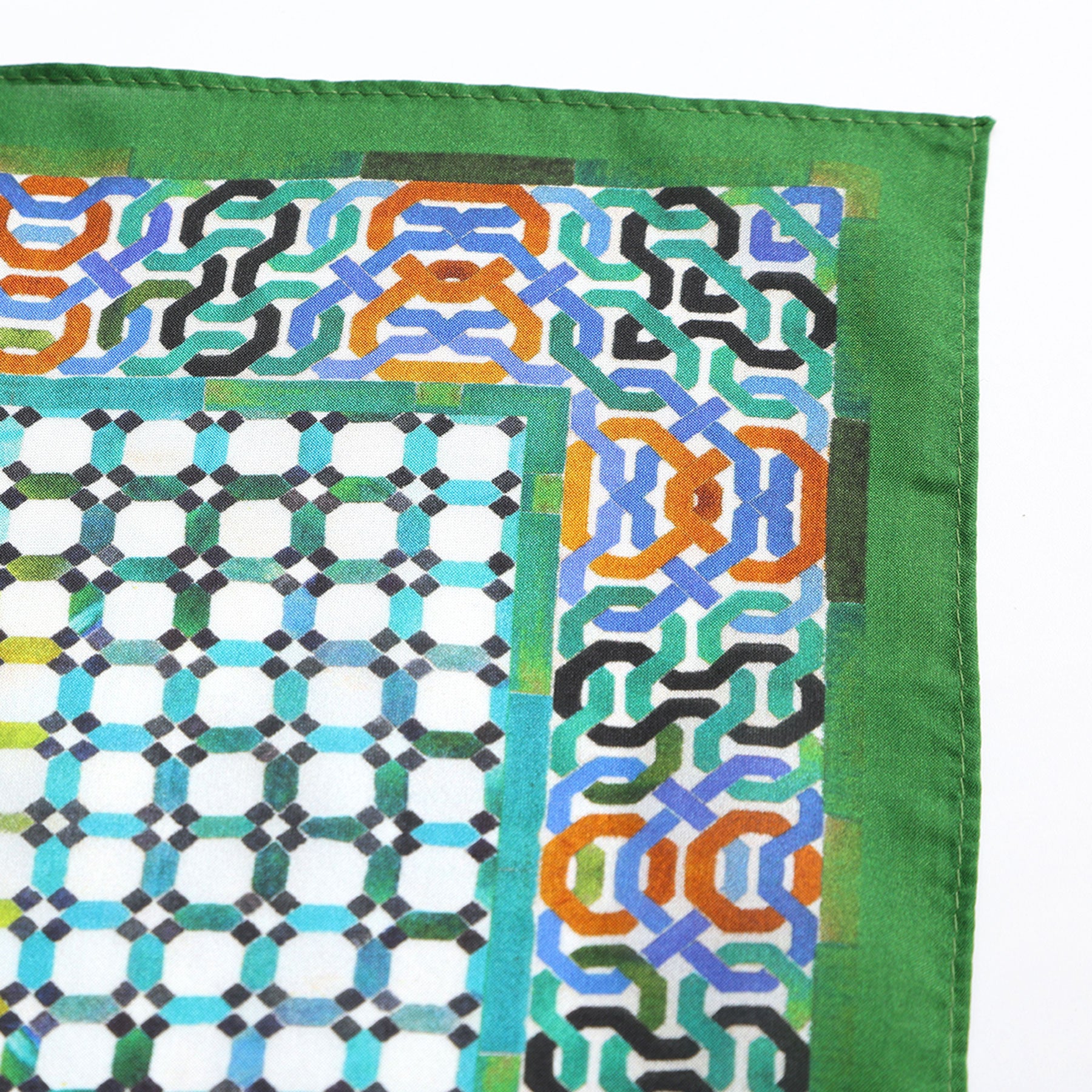 The Coloful Neckerchief 100% Silk features a green-bordered fabric with blue, orange, black, and white geometric patterns inspired by traditional mosaic designs, showcasing Spanish craftsmanship on a crisp white background.
