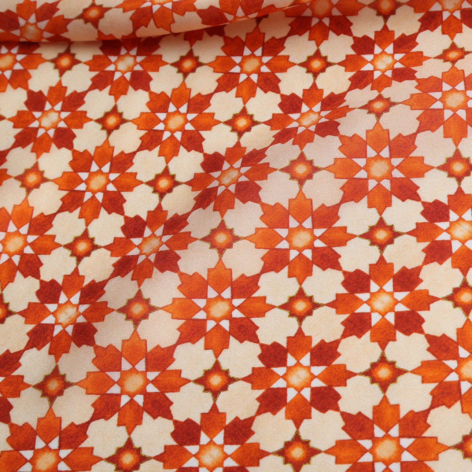The Silk Neckerchief Orange Islamic Art Print features a vibrant, symmetrical mosaic of orange, red, and cream star shapes inspired by Islamic art. Gentle folds add textured elegance to this striking accessory.