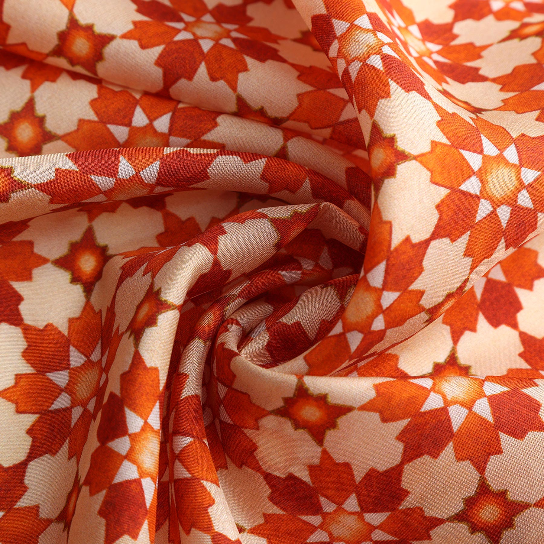 A close-up of the Silk Neckerchief Orange Islamic Art Print, showcasing its vibrant orange and cream geometric star pattern inspired by Islamic art, arranged in swirling folds to highlight its smooth texture and striking design.