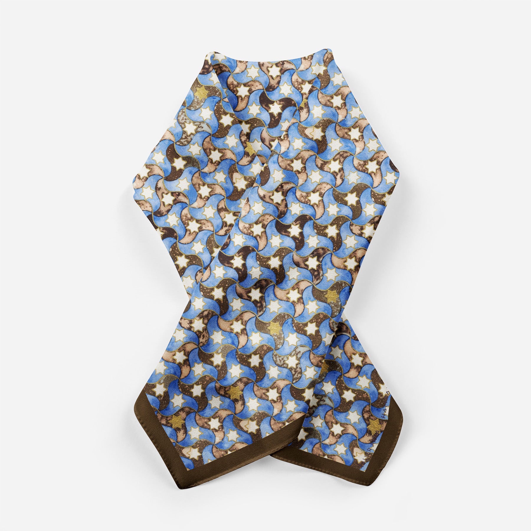 The Silk Square Scarf for Women Brown features abstract interlocking dog patterns in blue, beige, brown, and white with a dark brown border, inspired by Islamic art motifs and Spanish craftsmanship.