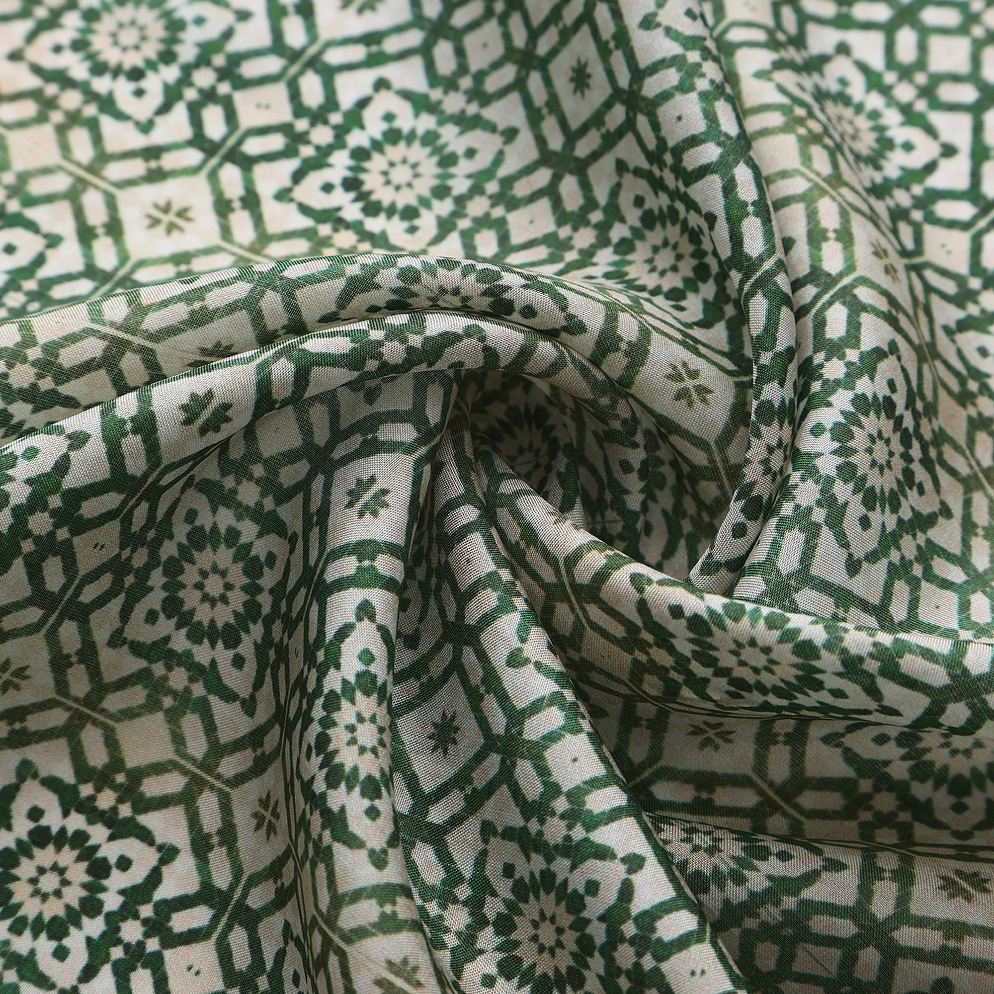 Close-up of the Azahar silk print: the fine green lattice on ivory