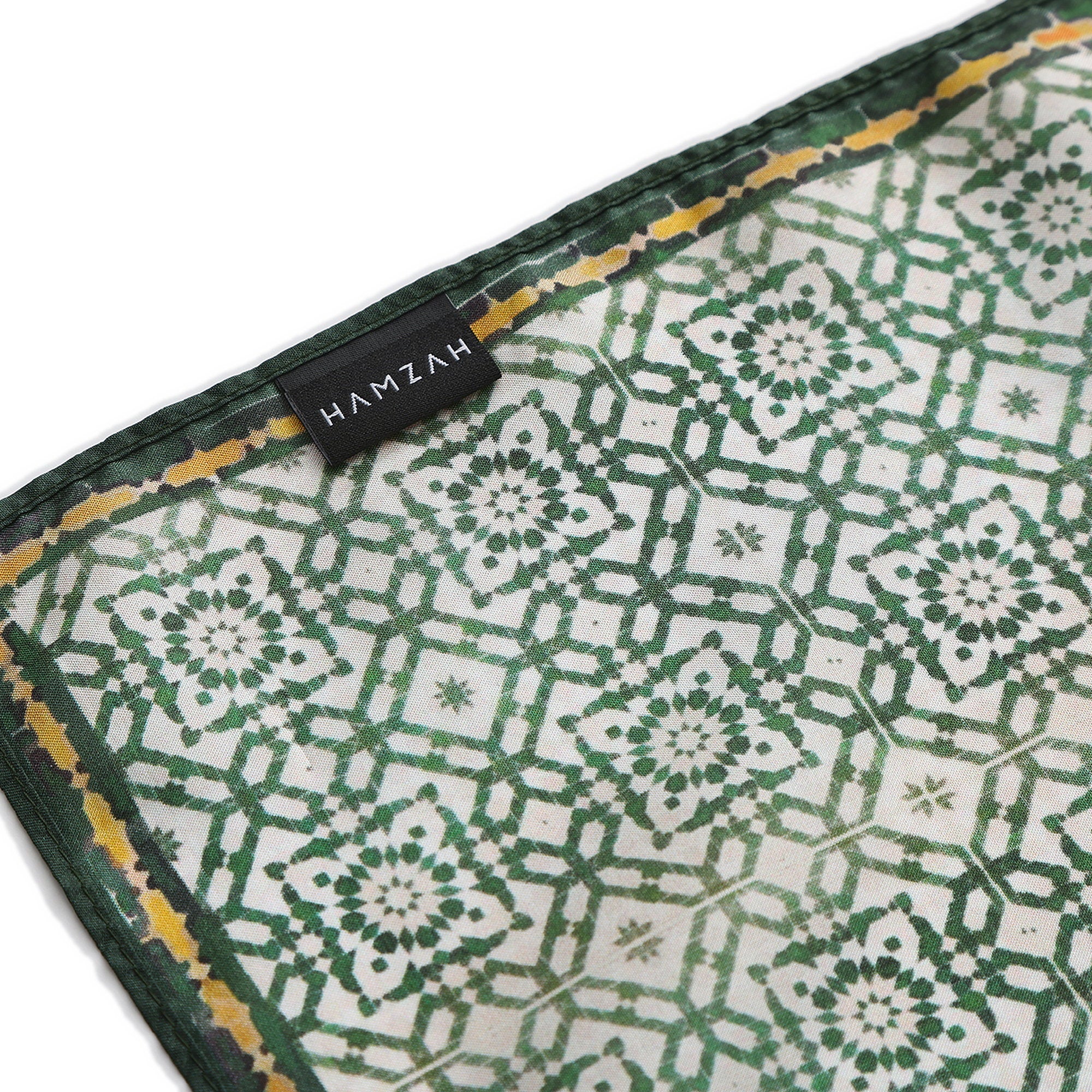 Corner of the Green Silk Square Scarf Azahar with the Hamzah woven label