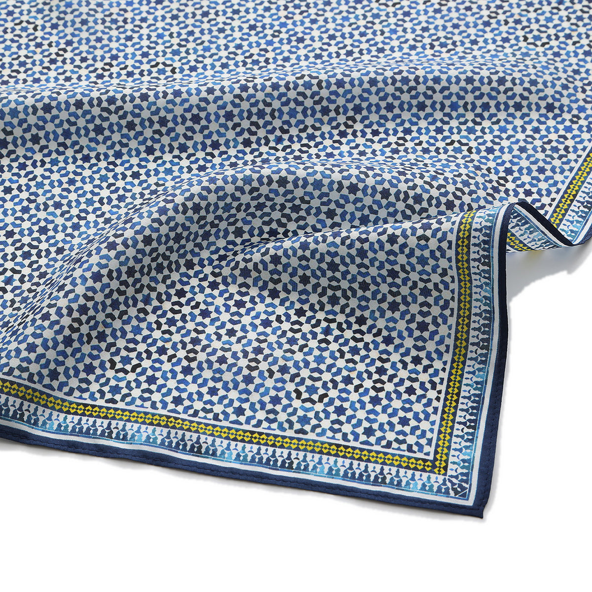 Close-up of the Basma silk print: the cobalt and navy star lattice on white