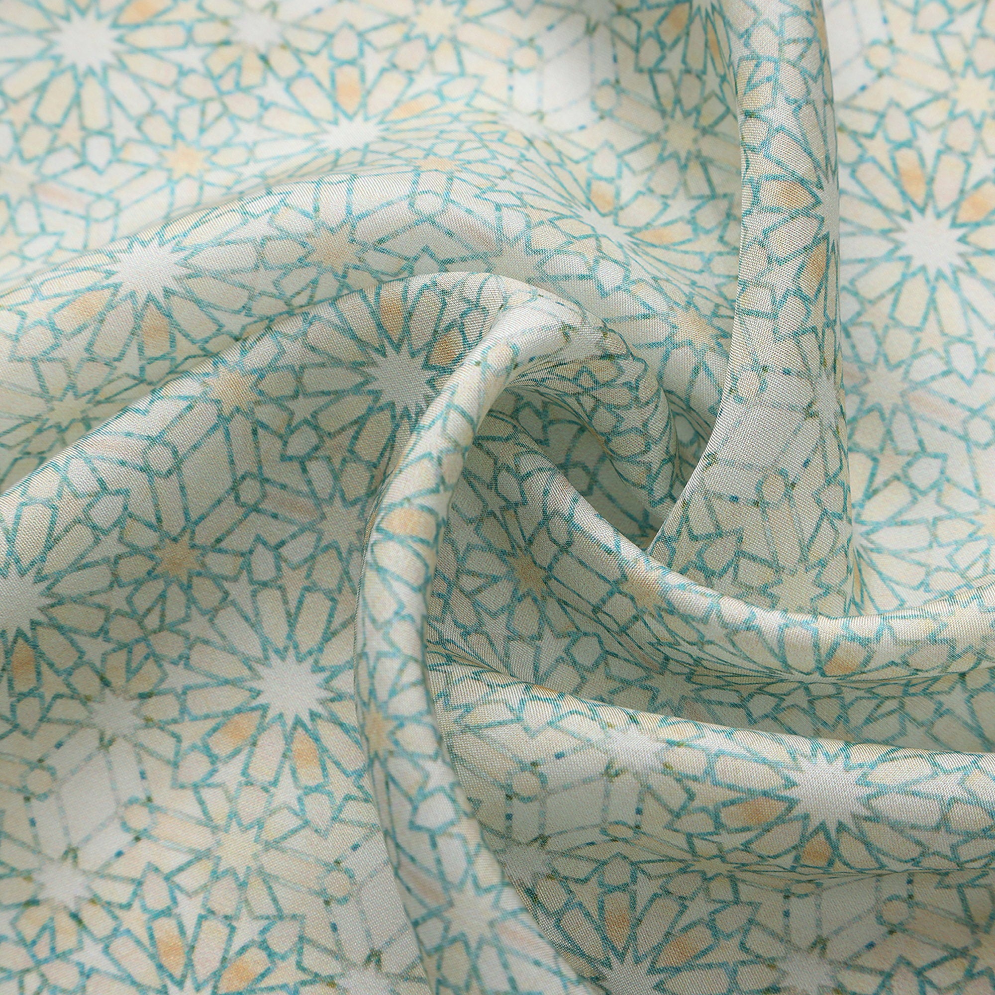 Close-up of the Lubna silk print: the fine turquoise star lattice on ivory