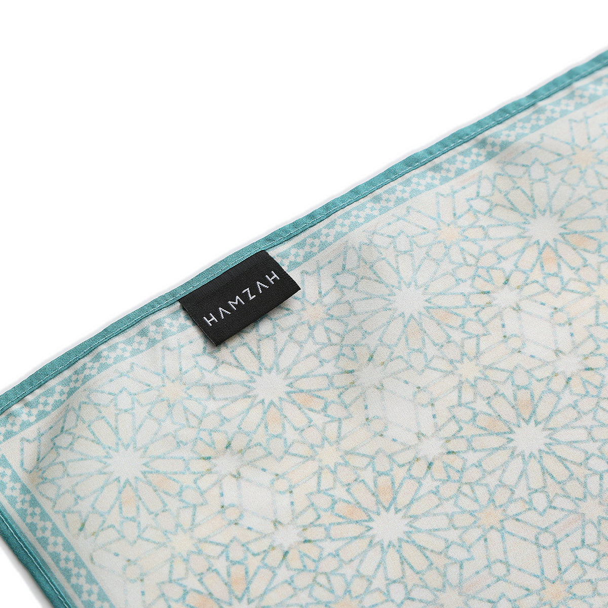 Folded corner of the Turquoise Silk Square Scarf Lubna, showing the border