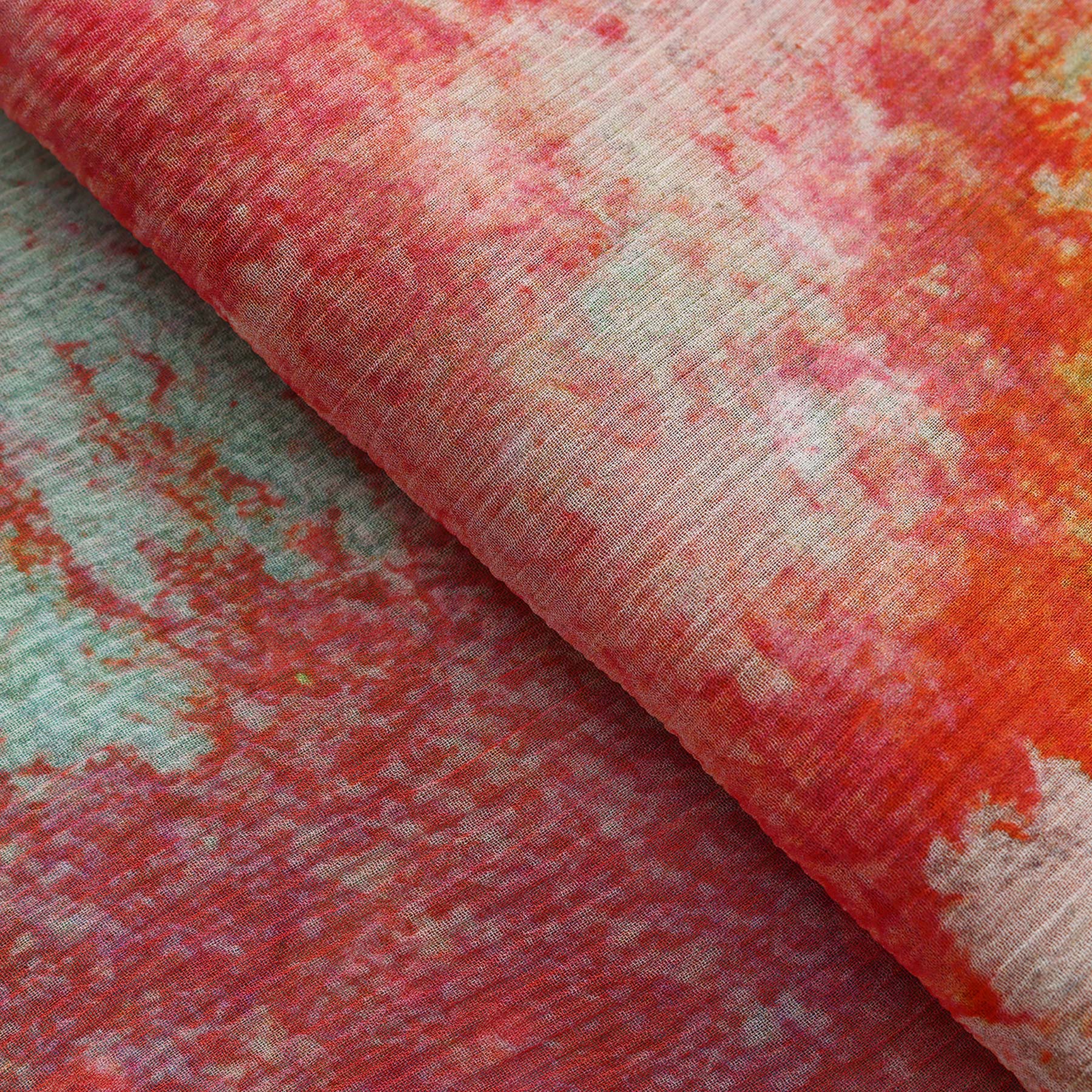 Close-up of the Multicolor Silk Scarf Fucsia Paradis, featuring a soft muslin silk fabric with a watercolor-inspired blend of red, pink, orange, and green shades—wearable art with elegant folds.