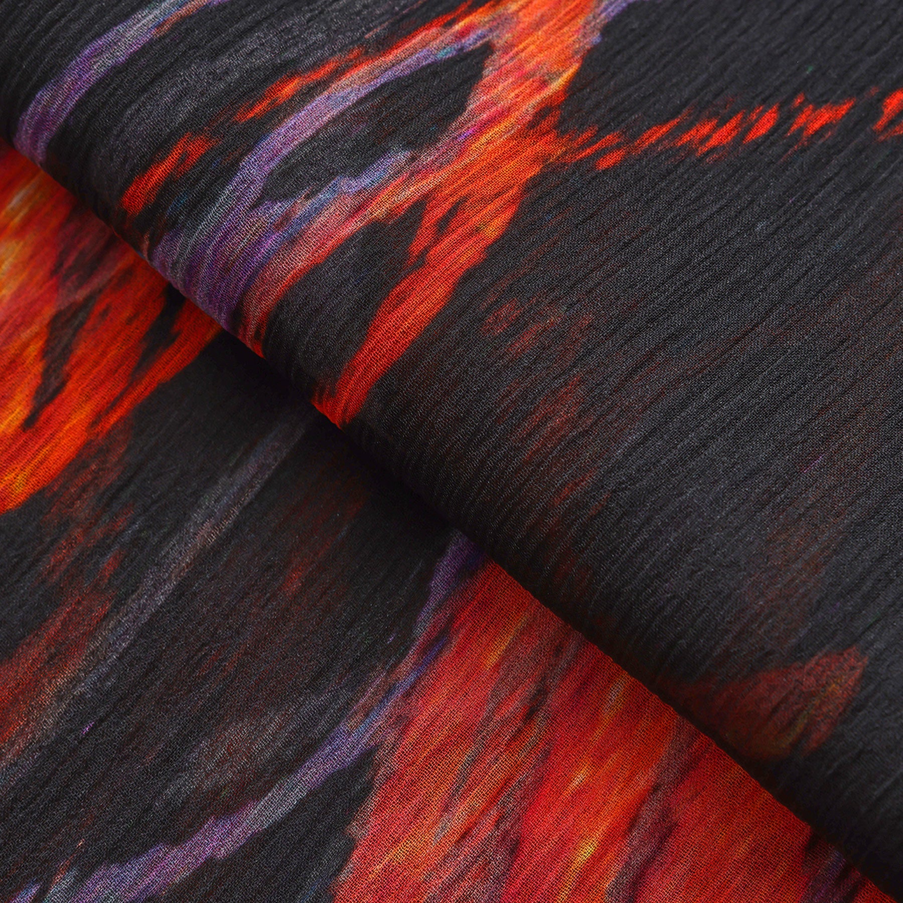 Close-up of the Black & Red Silk Scarf Anubis, crafted from textured muslin silk and featuring bold red, orange, and purple streaks on a dark background—an abstract pattern that turns this accessory into wearable artwork.