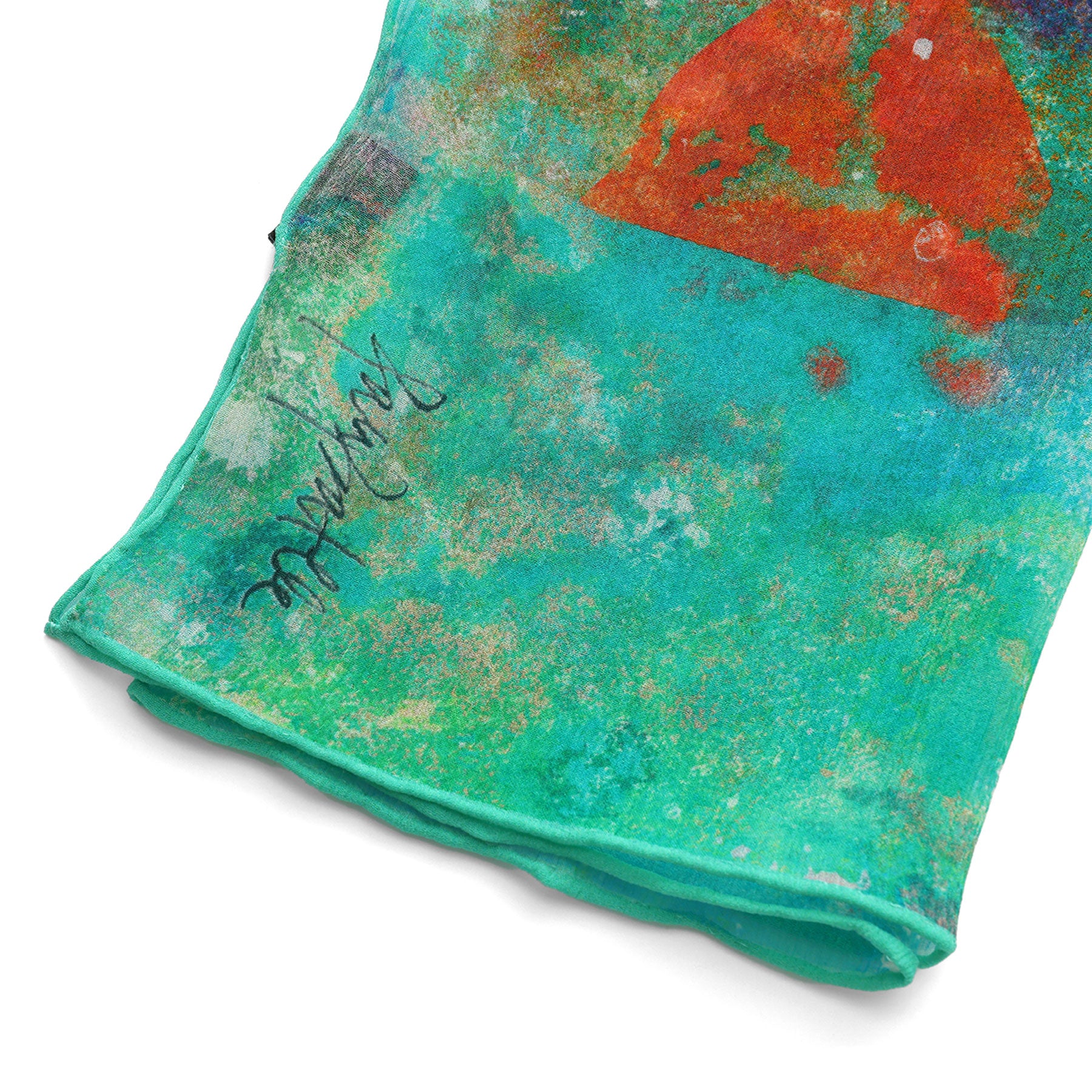 A close-up of the vibrant Natural Silk Scarf Mundos Ocultos, featuring abstract teal and green patterns, an orange-red triangle, and a visible black signature near the edge.