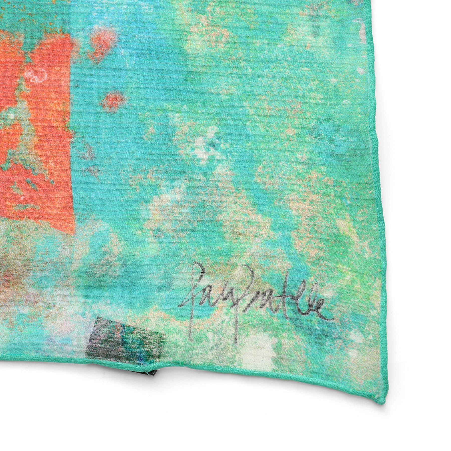 A close-up of the Natural Silk Scarf Mundos Ocultos shows teal and green muslin silk with abstract orange and white patterns. A handwritten black signature near the bottom right marks this unique wearable artwork.