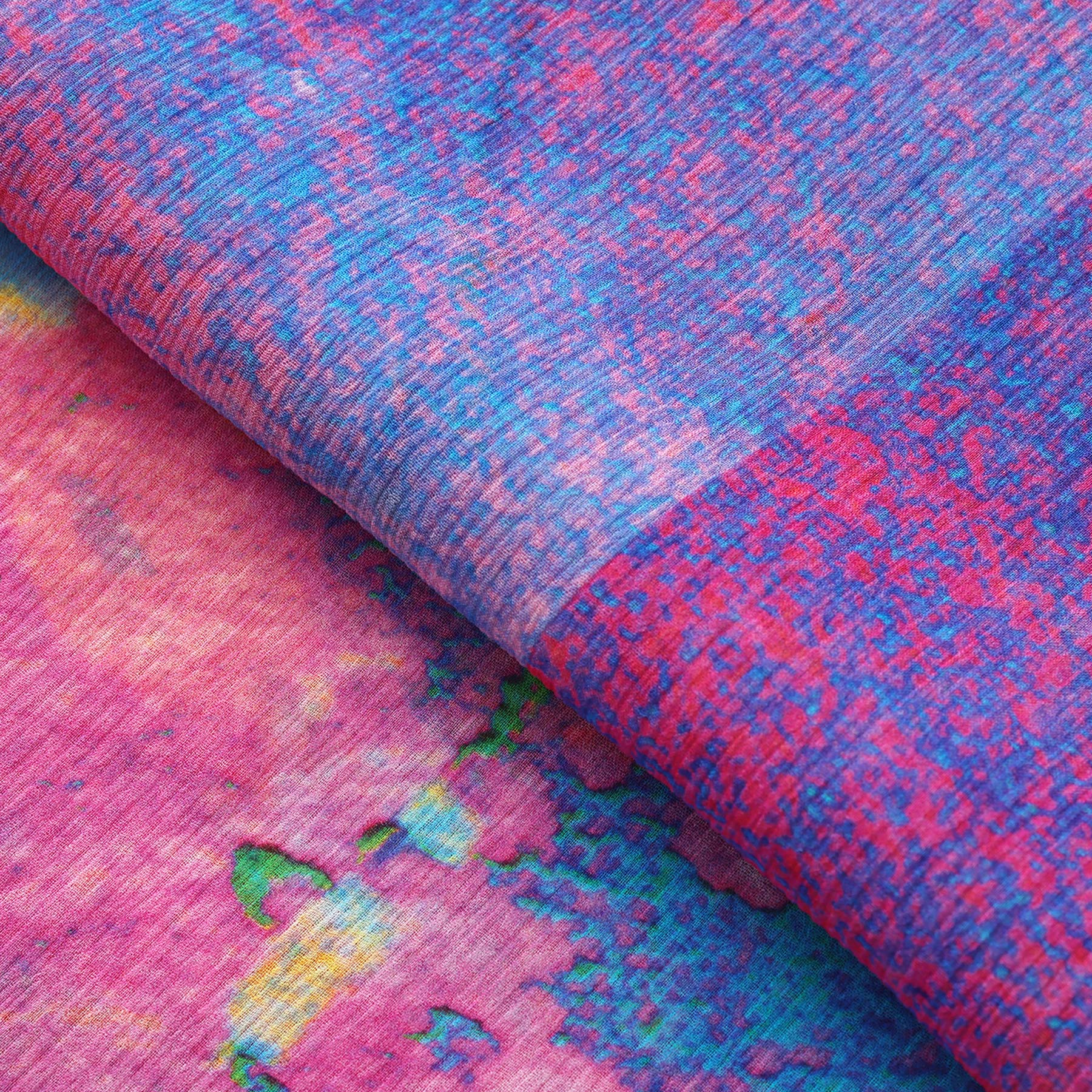 A close-up of the Multicolor Silk Scarf Océano Fucsia displays vibrant pink, blue, and purple hues with abstract patterns, blending bold style and artful design for a visually dynamic wearable artwork.